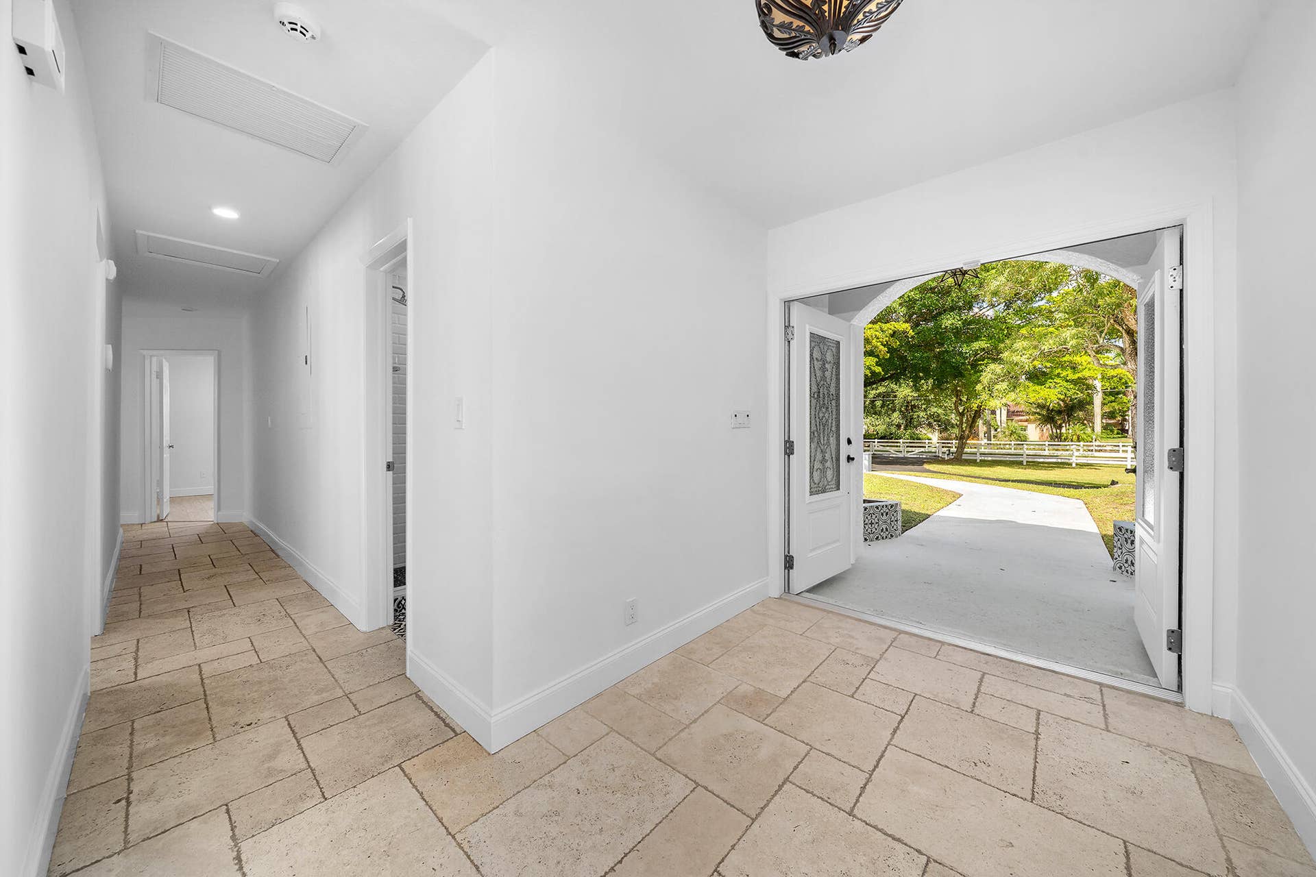 4950 Thoroughbred Lane, Southwest Ranches, FL 33330 Foyer featuring light-toned tile flooring, an arched doorway, and double entry doors with decorative glass inserts
