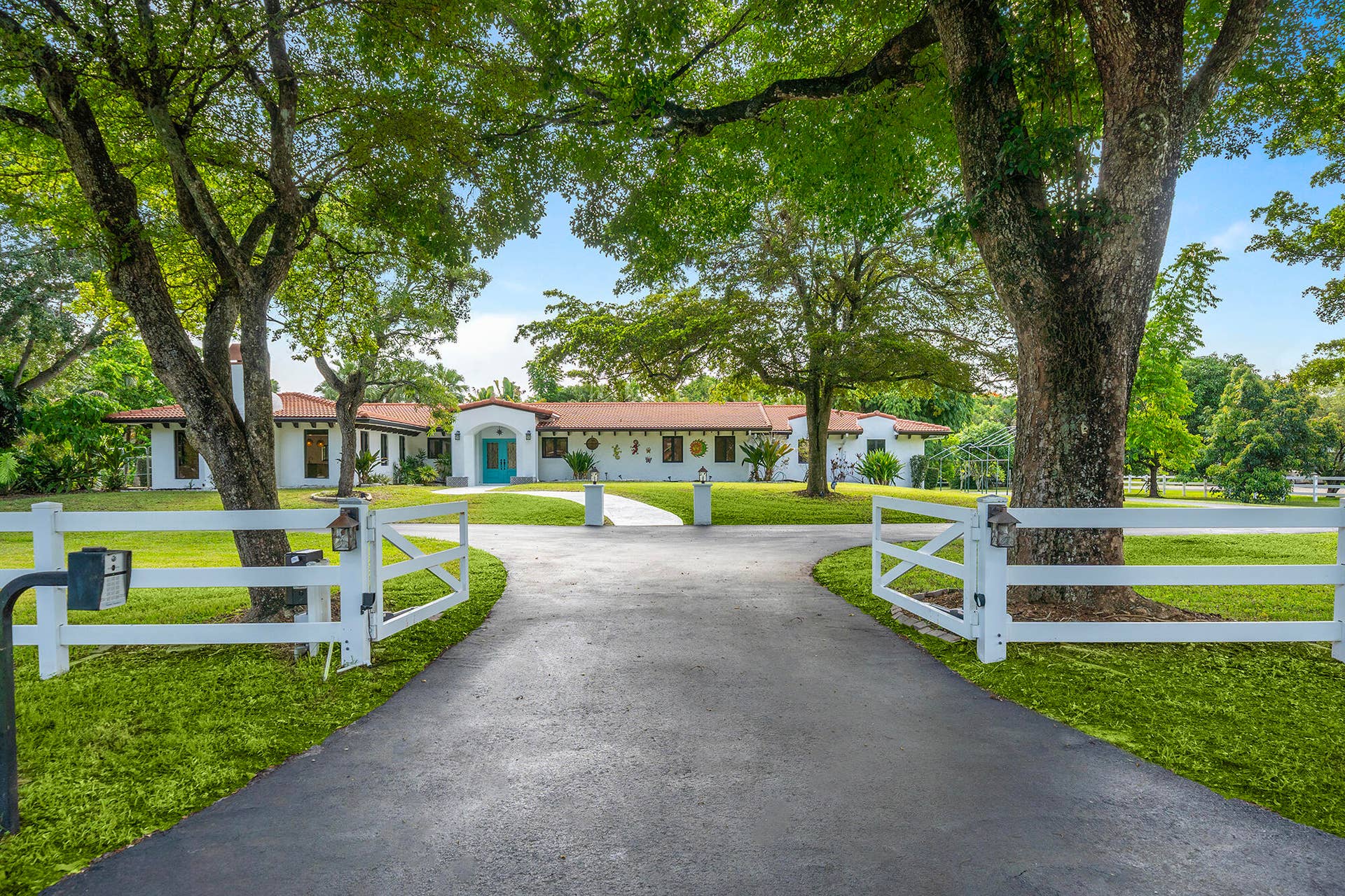 4950 Thoroughbred Lane, Southwest Ranches, FL 33330 Beautifully updated residence featuring a newer terracotta tile roof, white stucco exterior, and a inviting entryway
