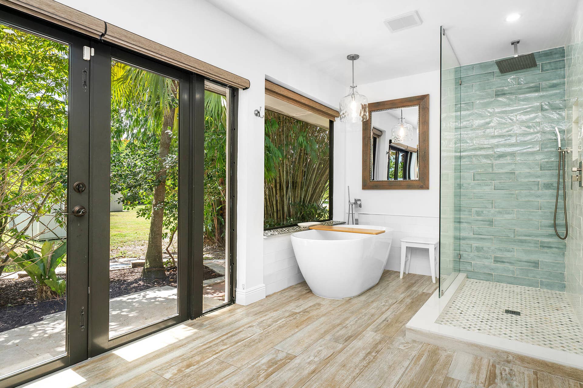 4950 Thoroughbred Lane, Southwest Ranches, FL 33330 Contemporary bathroom featuring a freestanding soaking tub, glass-enclosed shower with rain head, wood-finish tile flooring, and large outdoor-facing windows