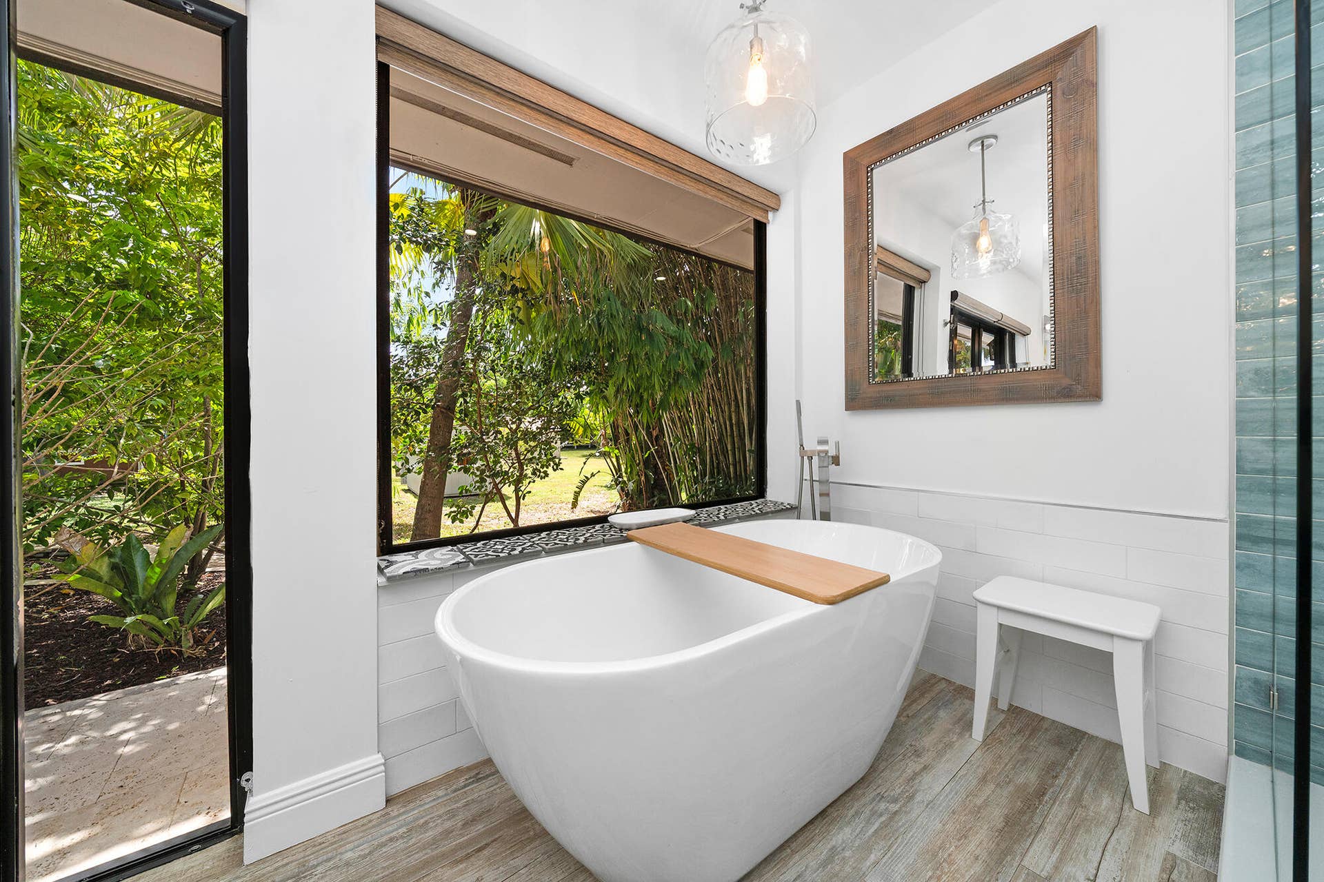 4950 Thoroughbred Lane, Southwest Ranches, FL 33330 Freestanding soaking tub with a floor-mounted faucet and a large window overlooking lush landscaping