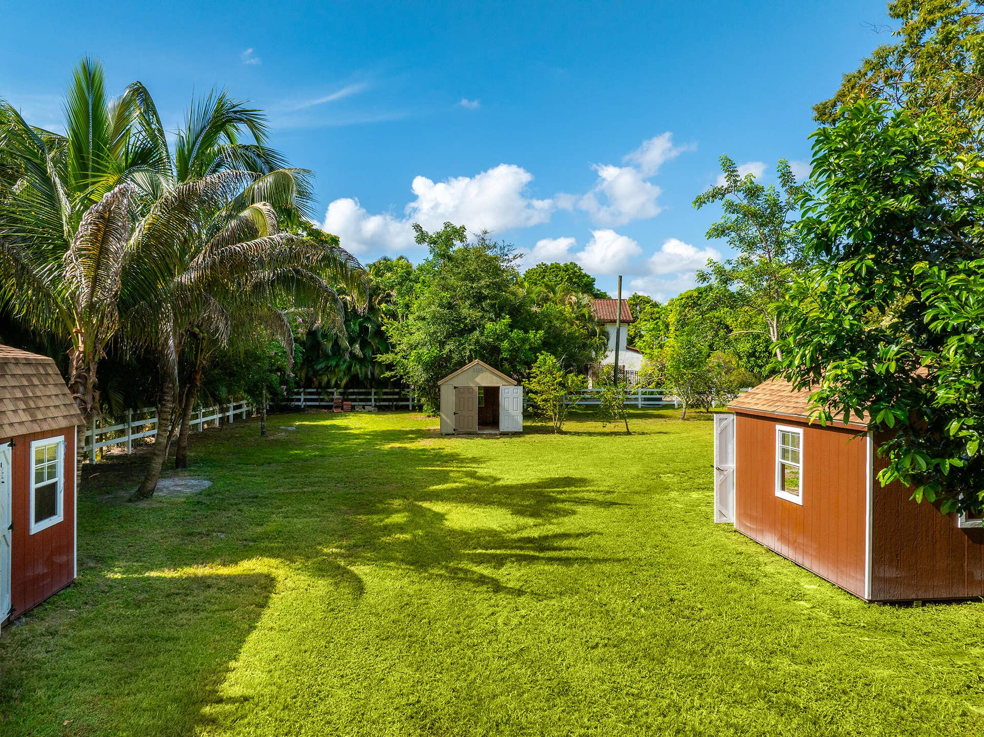 4950 Thoroughbred Lane, Southwest Ranches, FL 33330 Expansive green lawn featuring mature trees and multiple outbuildings
