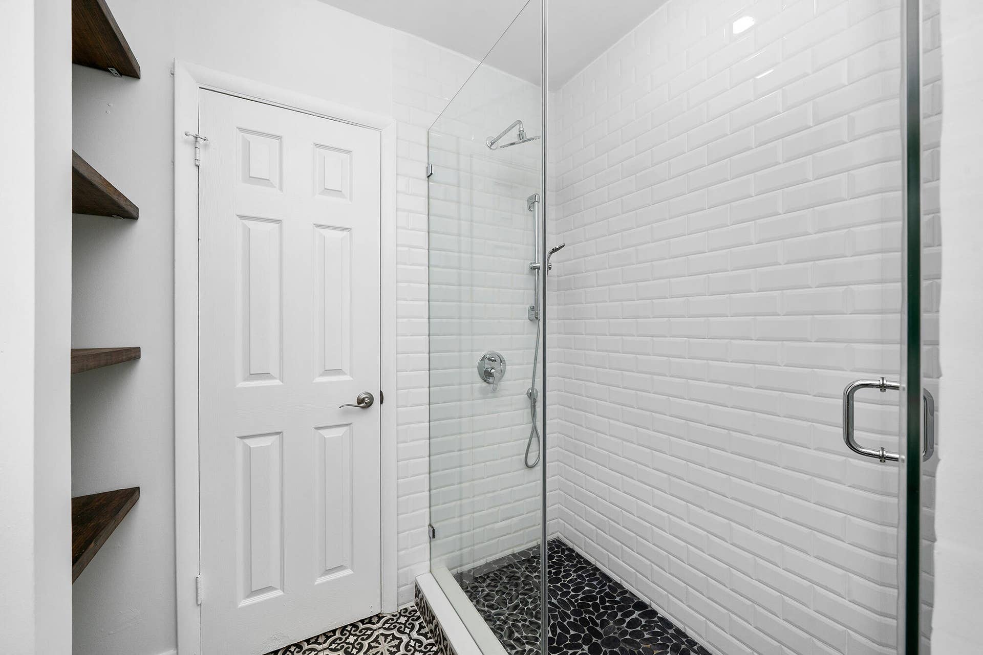 4950 Thoroughbred Lane, Southwest Ranches, FL 33330 Frameless glass shower enclosure featuring white subway tile walls and a dark pebble floor