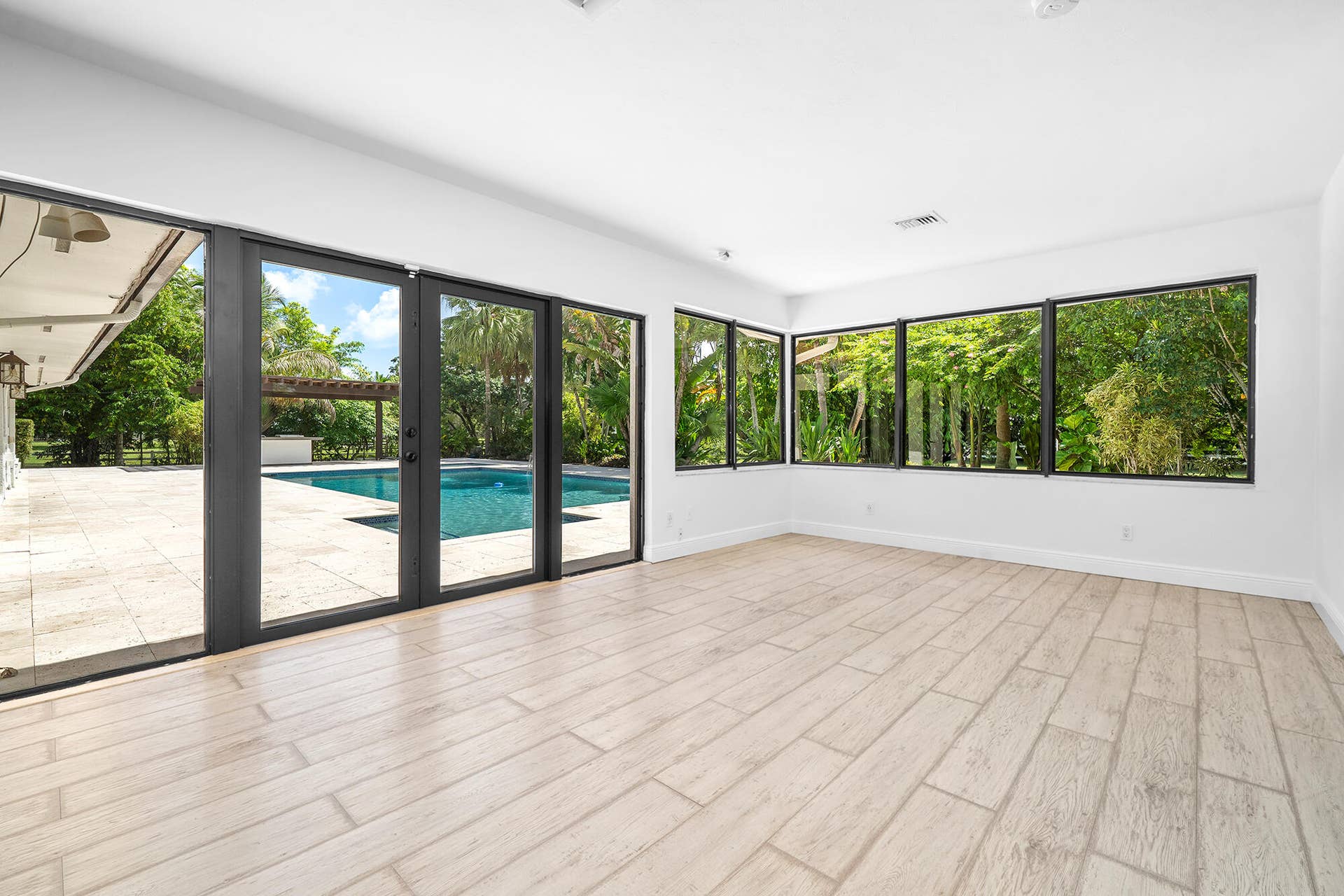 4950 Thoroughbred Lane, Southwest Ranches, FL 33330 Expansive interior space featuring light wood-finish flooring, white walls, and a recessed ceiling