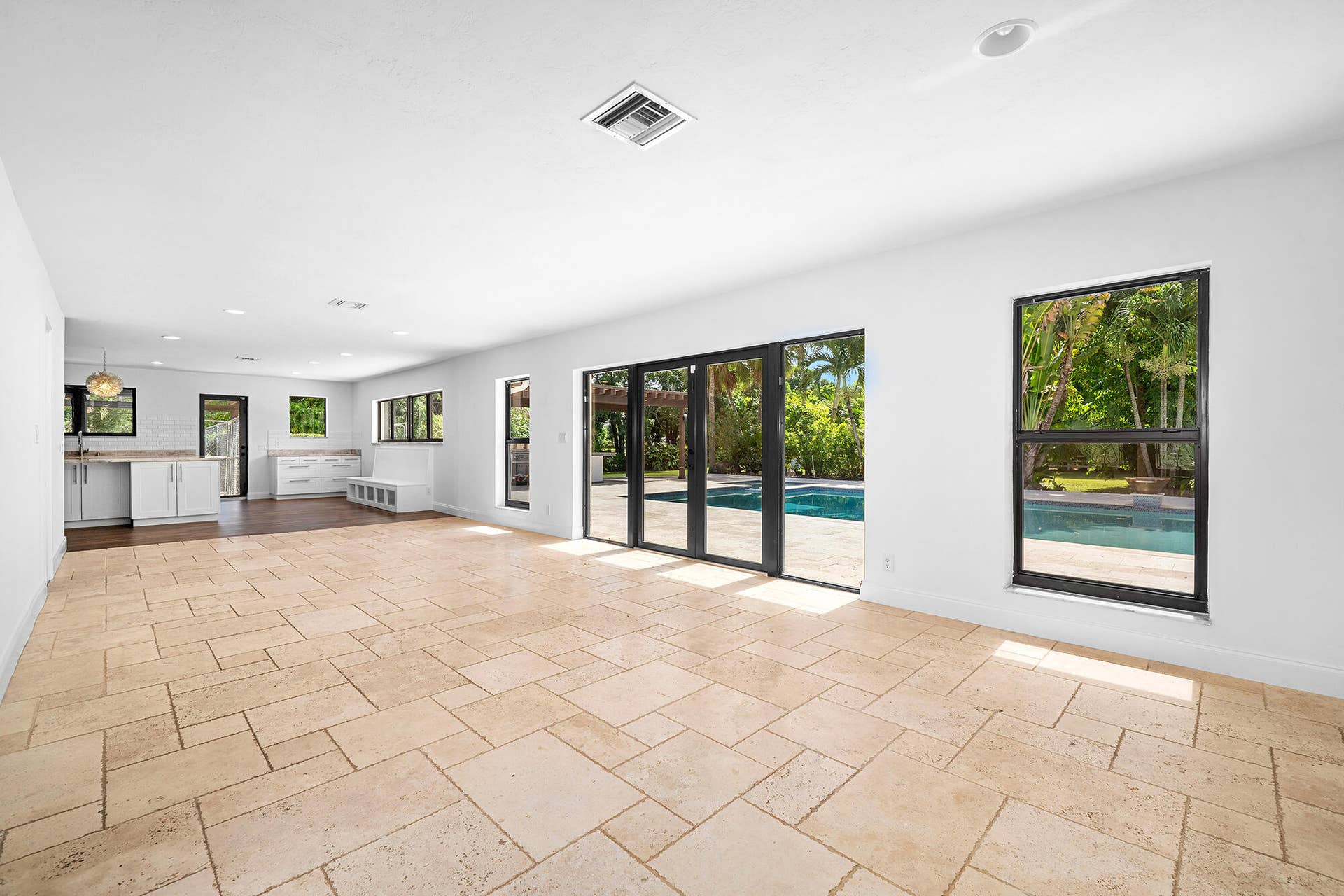 4950 Thoroughbred Lane, Southwest Ranches, FL 33330 Expansive living area with travertine marble flooring and multiple windows