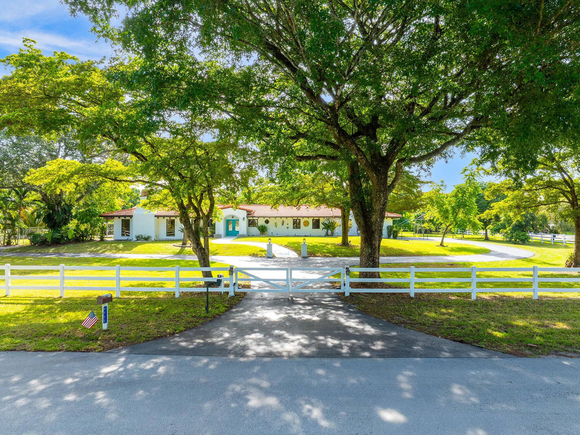 4950 Thoroughbred Lane, Southwest Ranches, FL 33330 Beautifully updated residence featuring a newer terracotta tile roof, white stucco exterior, and sprawling land.