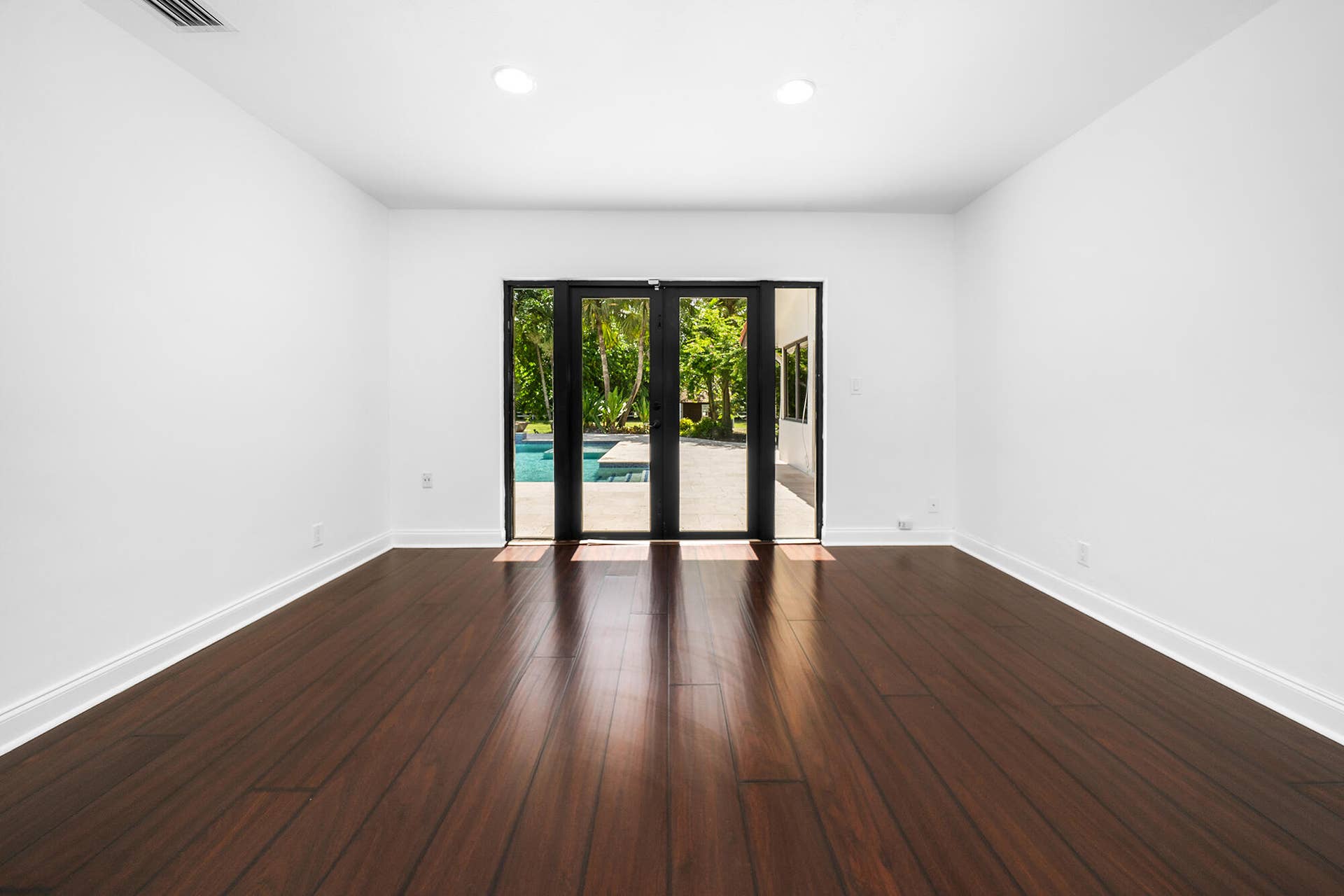 4950 Thoroughbred Lane, Southwest Ranches, FL 33330 Wood-finish flooring and a view to the pool and patio