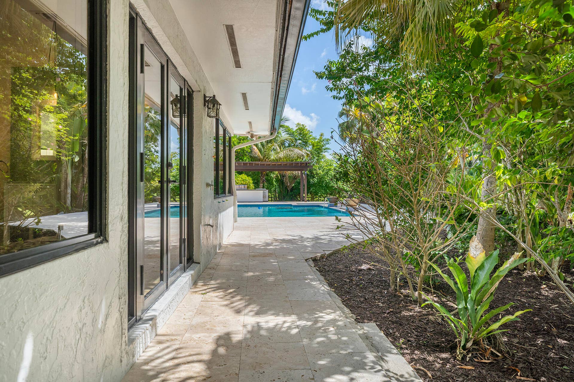 4950 Thoroughbred Lane, Southwest Ranches, FL 33330 Exterior patio featuring a textured stucco finish, and a travertine tiled walkway