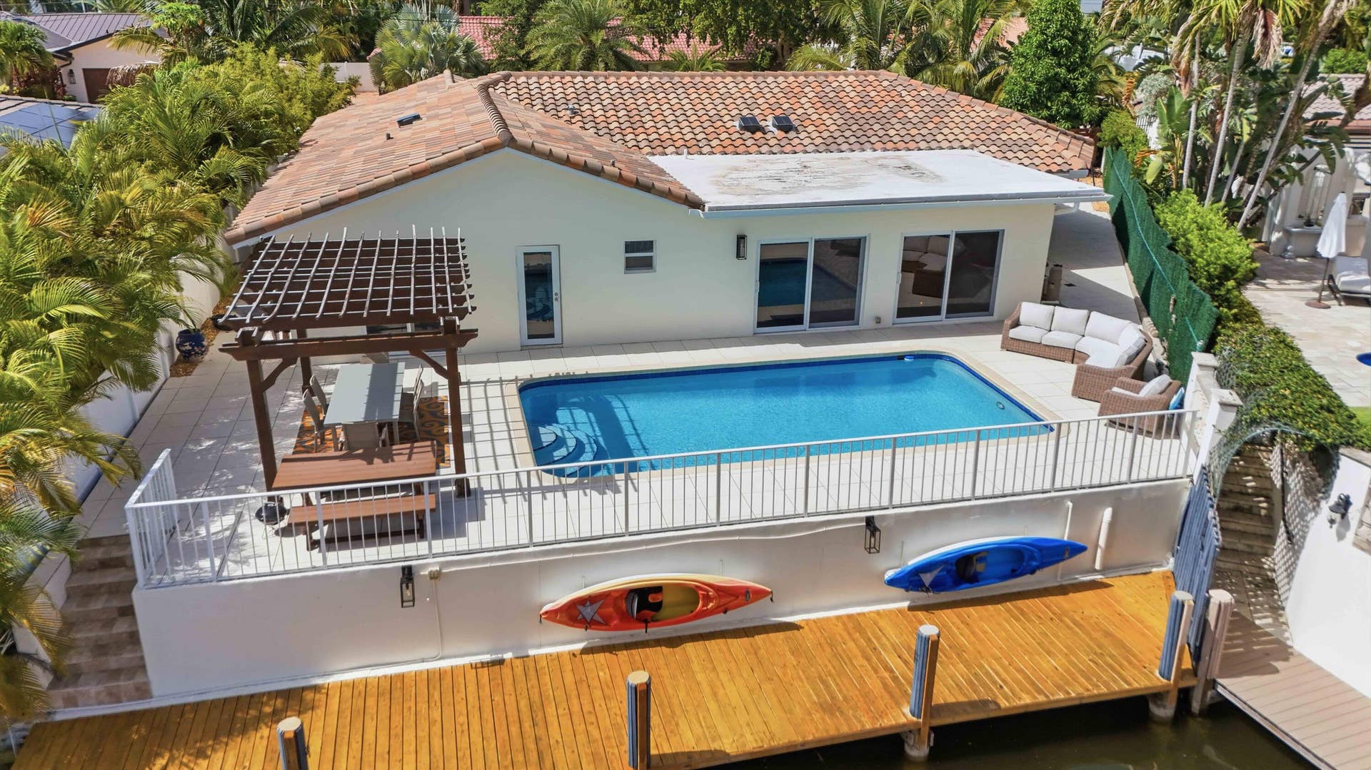3316 NE 40TH Court, Fort Lauderdale, FL 33308 Waterfront property featuring a private boat dock, a rectangular swimming pool, and an expansive paved patio