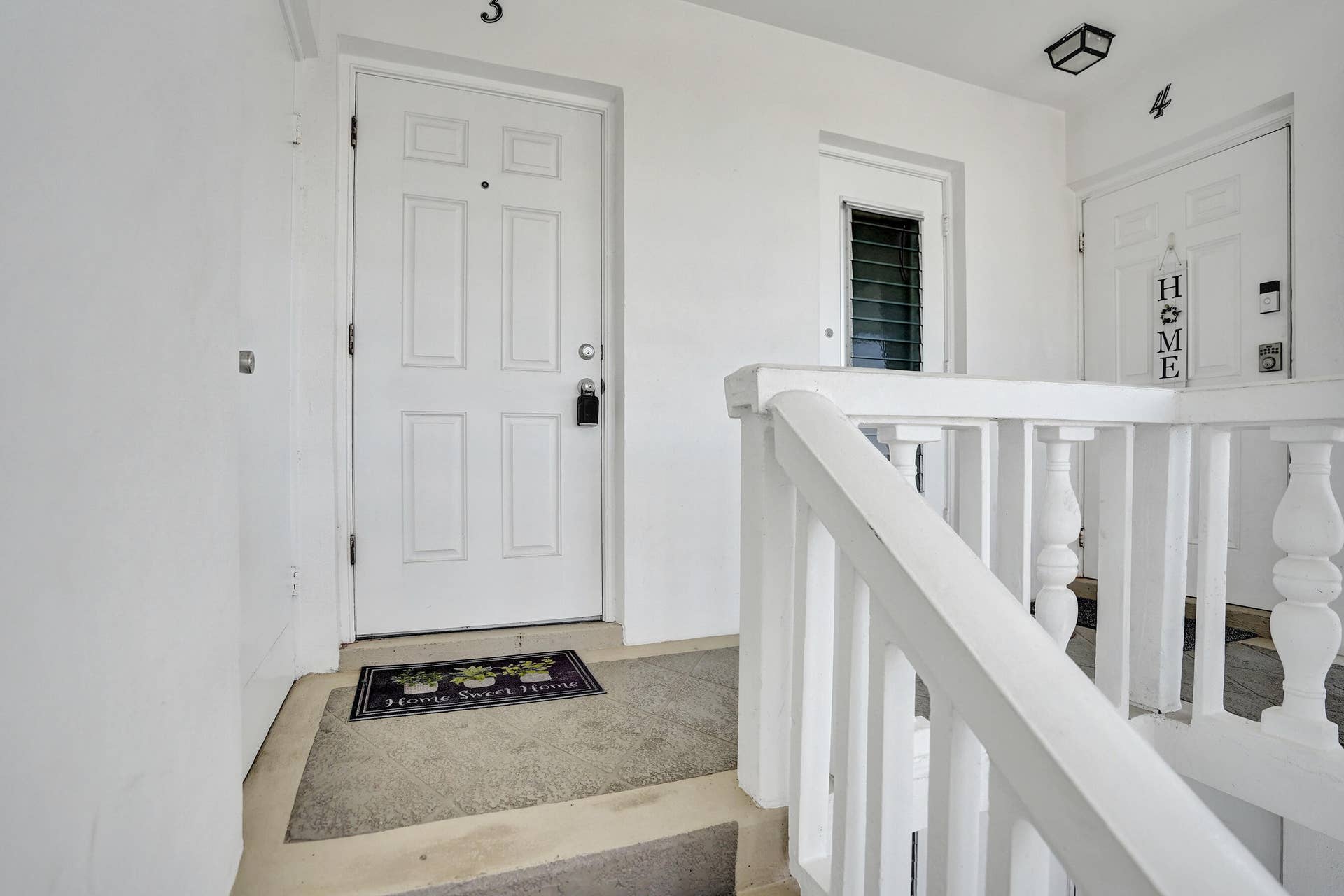 White paneled entry door with black hardware