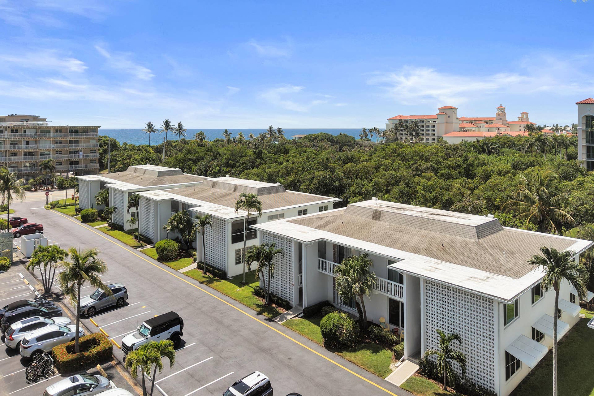 Multi-story residential buildings with balconies and a partial ocean backdrop