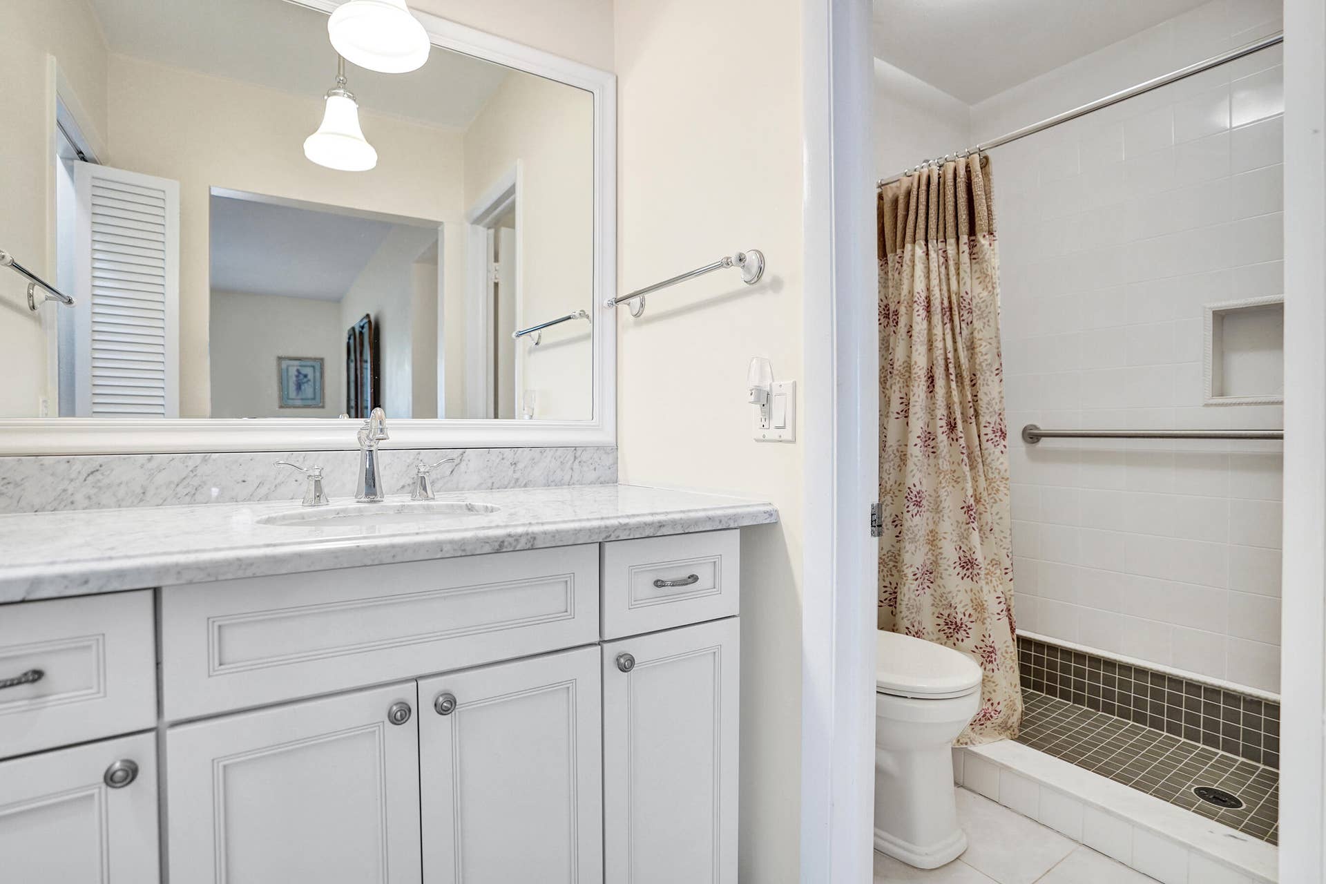 Primary Bathroom featuring a white vanity with a stone countertop, an undermount sink, and a large mirror