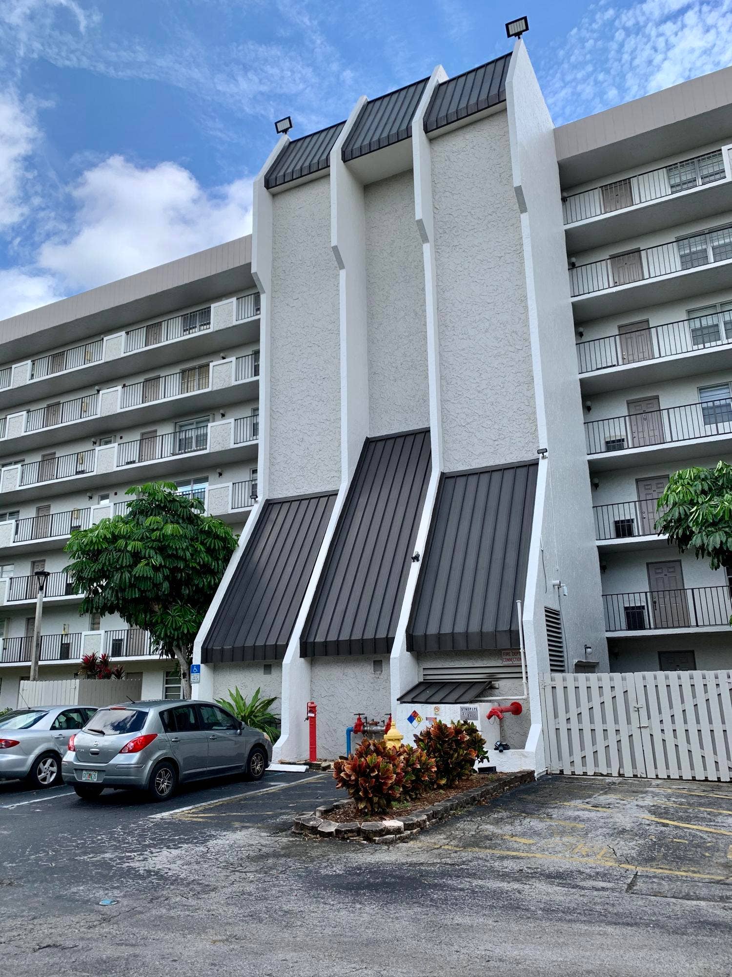 3100 W Rolling Hills Circle, #309, Davie, Davie, FL 33328 Multi-story building featuring textured white exterior siding and dark metal roofing details