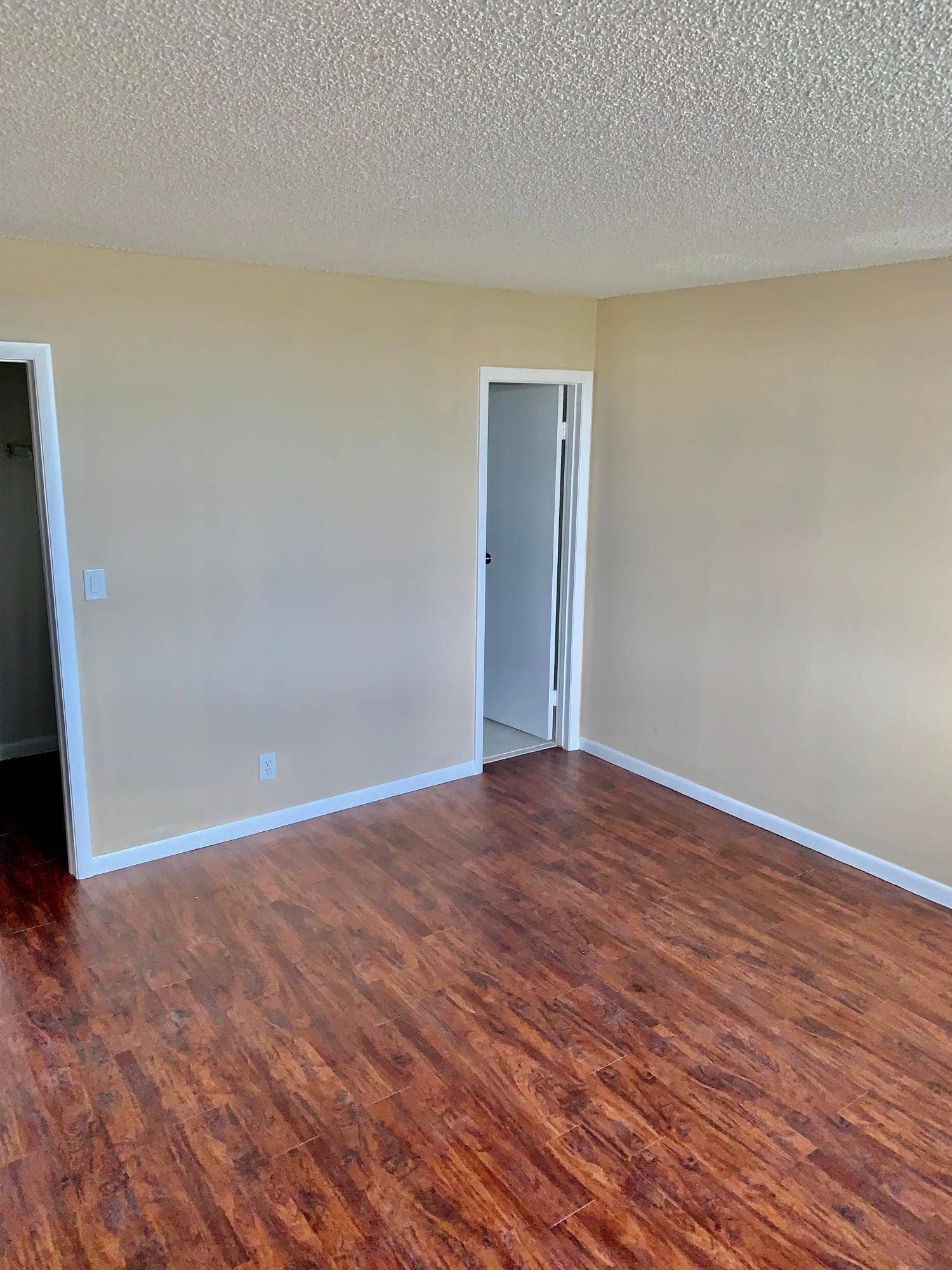 3100 W Rolling Hills Circle, #309, Davie, Davie, FL 33328 Spacious room featuring rich wood-finish flooring, neutral wall tones, white baseboards, and two entryways