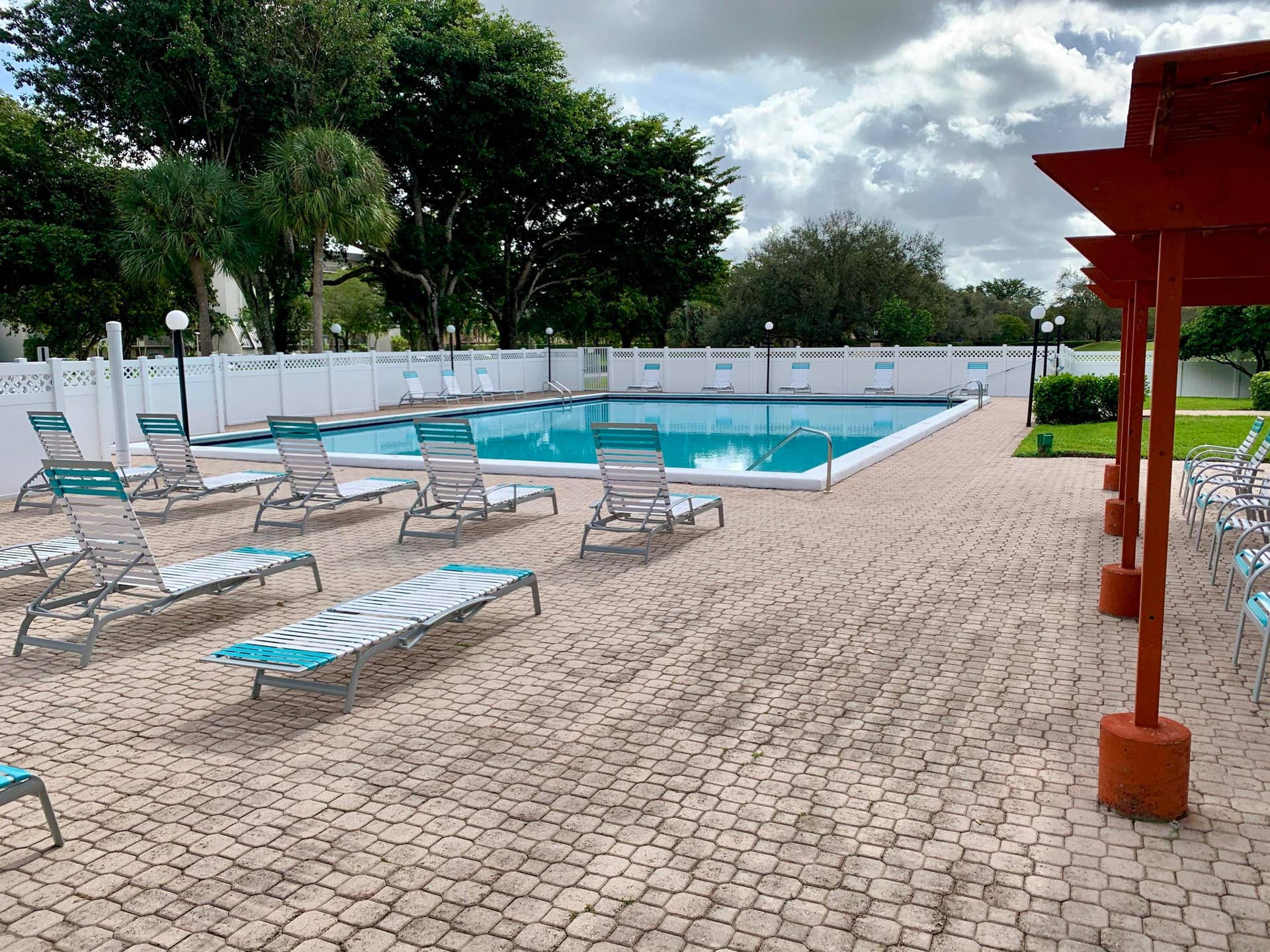 3100 W Rolling Hills Circle, #309, Davie, Davie, FL 33328 Community swimming pool featuring a perimeter fence, surrounding paver decking, and an adjacent pergola structure