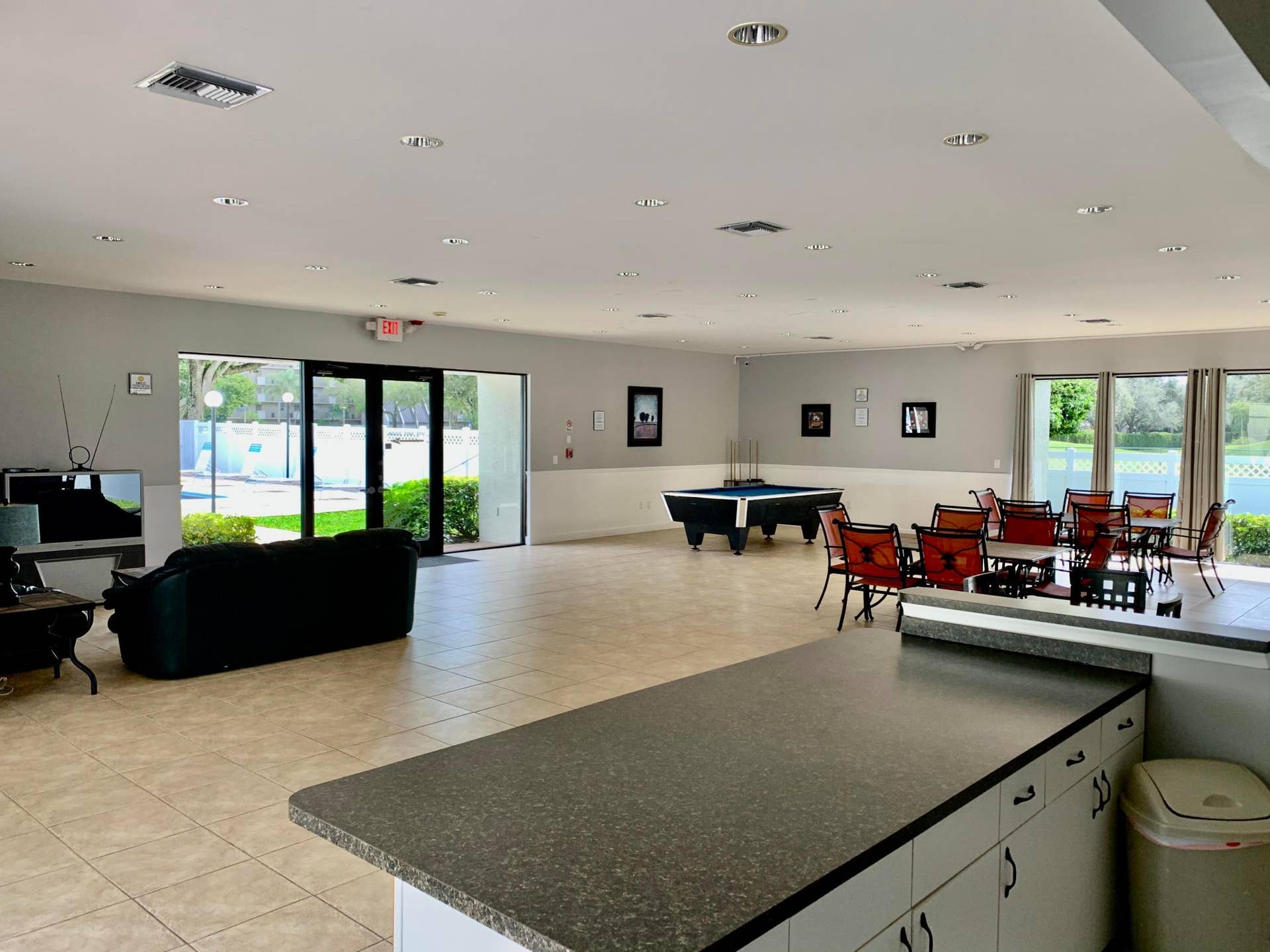 3100 W Rolling Hills Circle, #309, Davie, Davie, FL 33328 Expansive common area featuring tiled flooring, recessed lighting, a built-in counter with cabinetry, and large glass doors providing natural light