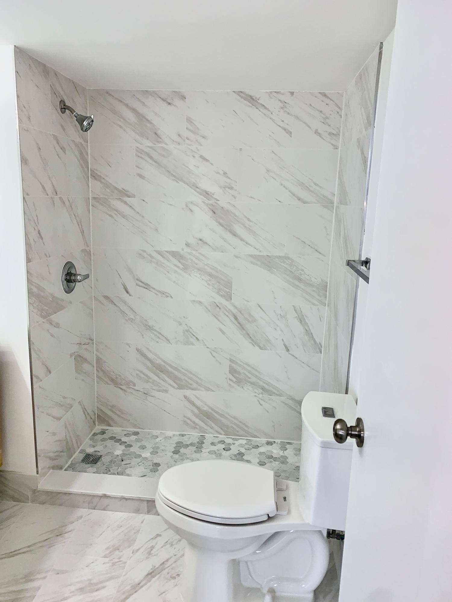 3100 W Rolling Hills Circle, #309, Davie, Davie, FL 33328 Bathroom featuring a walk-in shower with large format marble-look tile walls, a hexagonal mosaic tile shower pan, and a toilet