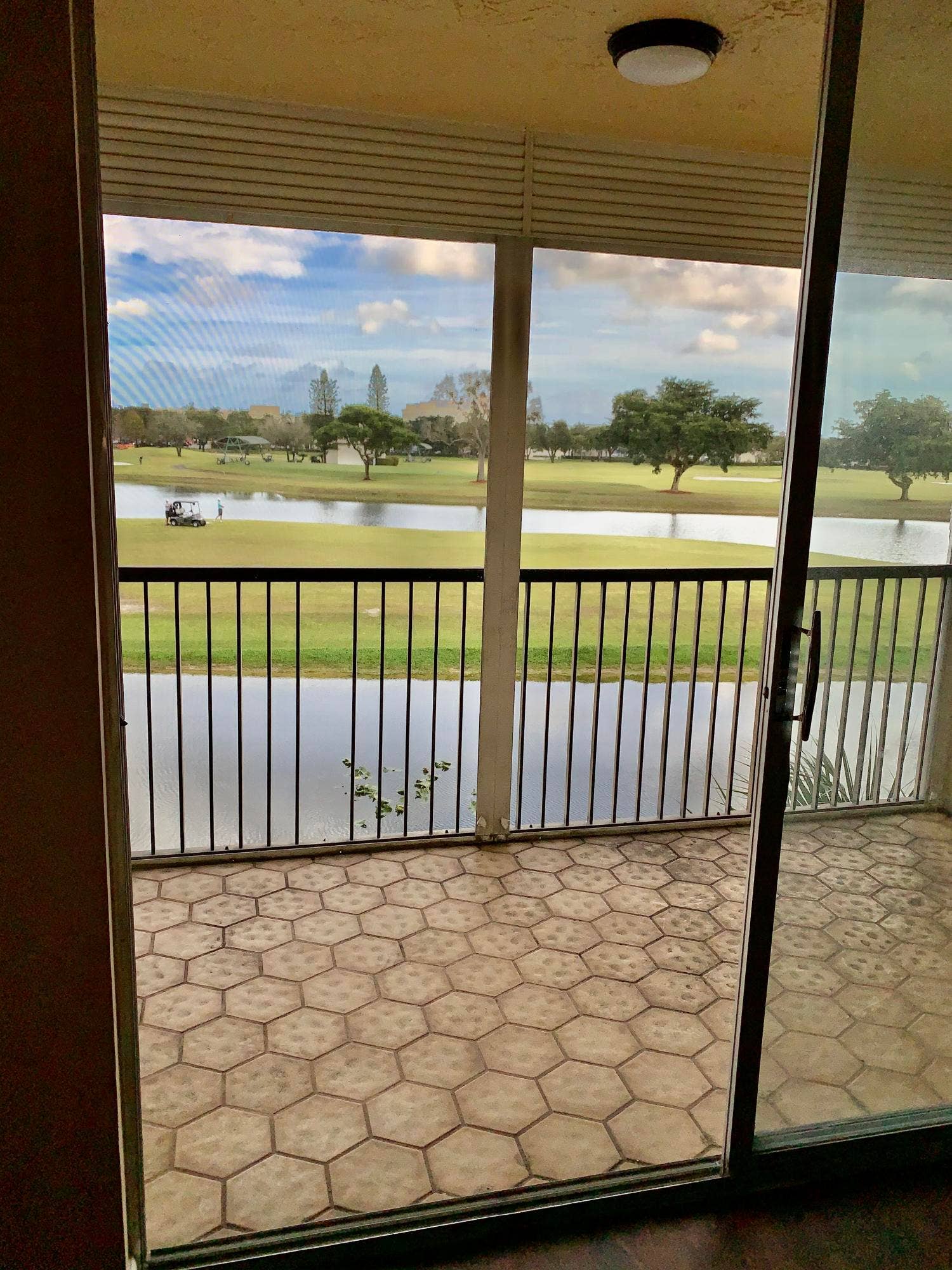 3100 W Rolling Hills Circle, #309, Davie, Davie, FL 33328 Patio featuring hexagonal tile flooring and a black metal railing overlooking a water feature and golf course