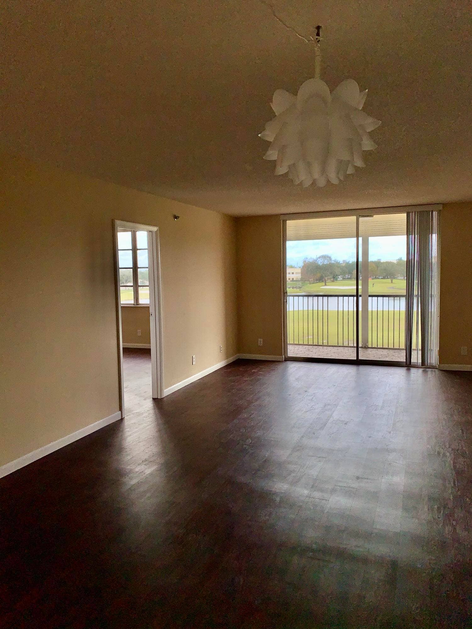 3100 W Rolling Hills Circle, #309, Davie, Davie, FL 33328 Spacious room featuring dark wood-finish flooring, neutral wall tones, and a distinctive chandelier