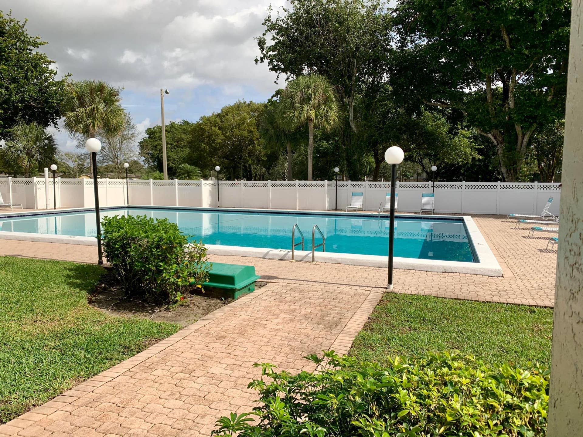 3100 W Rolling Hills Circle, #309, Davie, Davie, FL 33328 Swimming pool with white perimeter fencing, surrounding paver decking, and integrated lighting