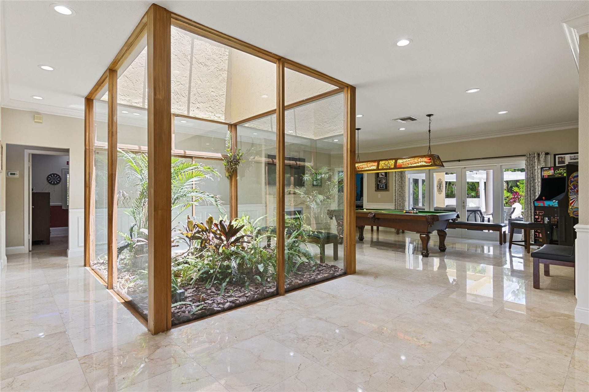 Interior atrium with lush plantings, framed by wood and glass panels