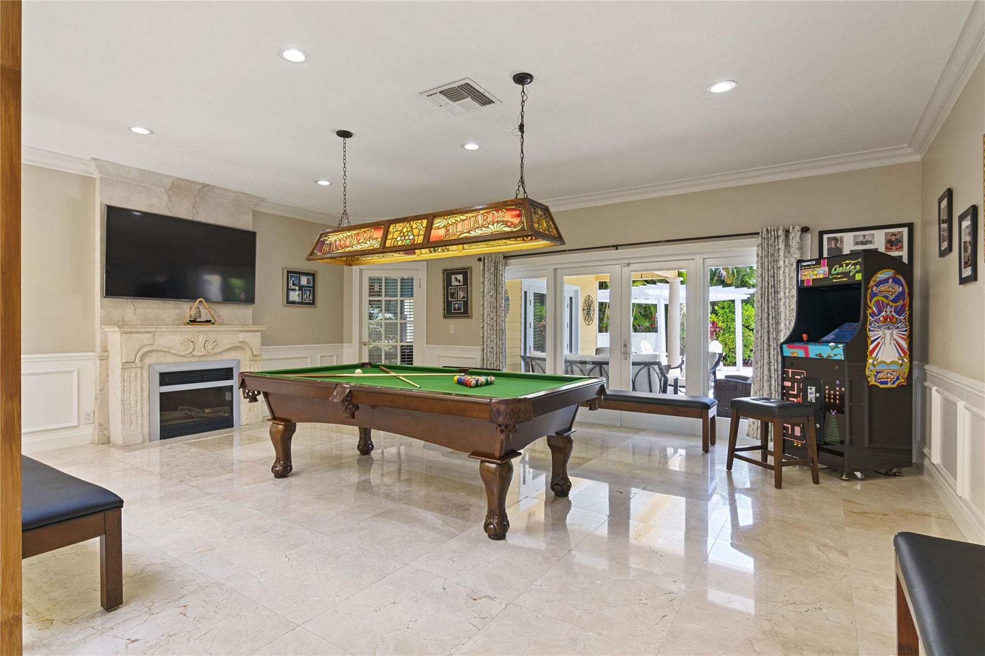 Spacious room featuring polished stone flooring and a decorative fireplace with an integrated television recess
