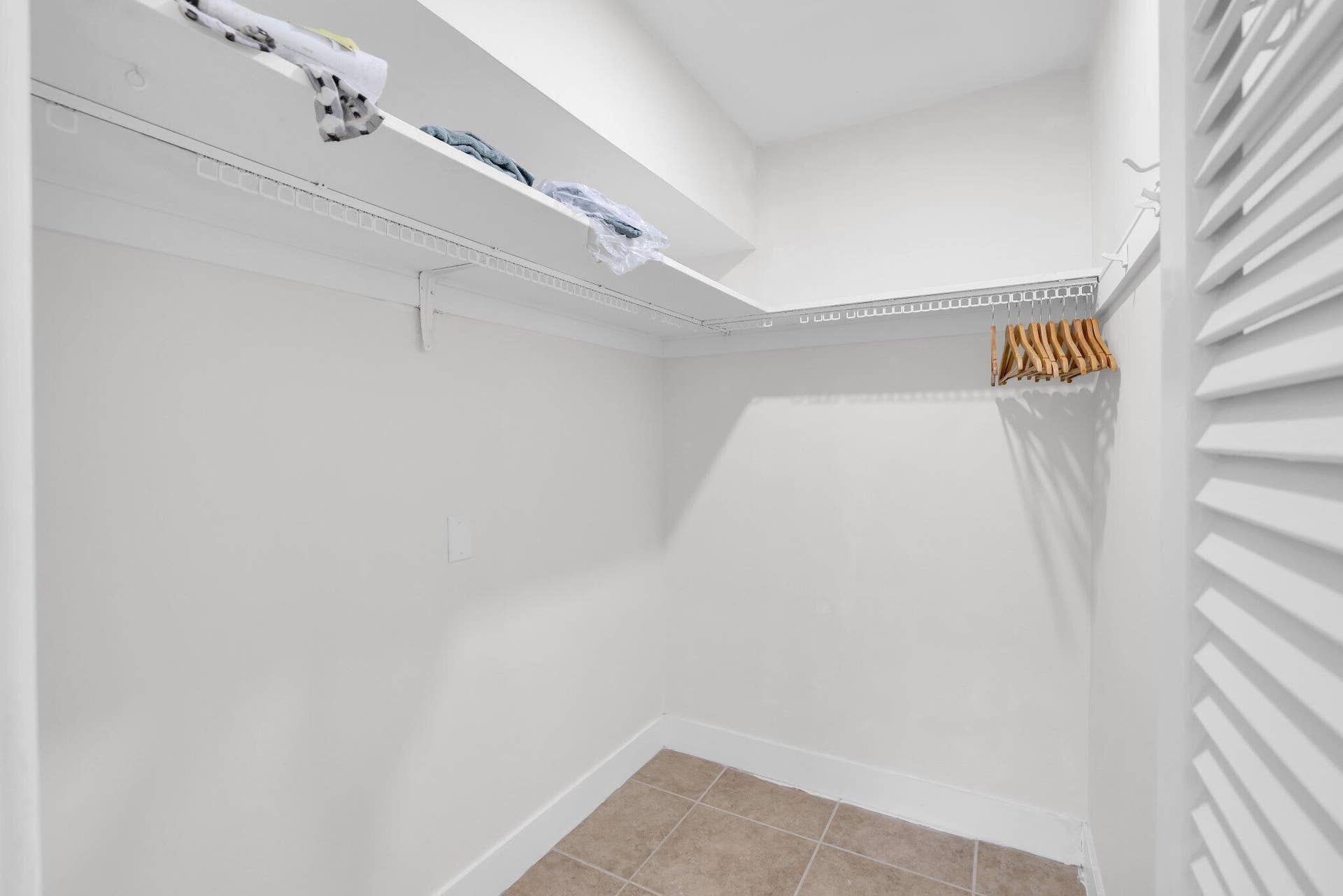 320 Inlet Way, #4, Palm Beach Shores, Palm Beach Shores, FL 33404 Walk-in closet featuring white wire shelving, a hanging rod, tile flooring, and a louvered door