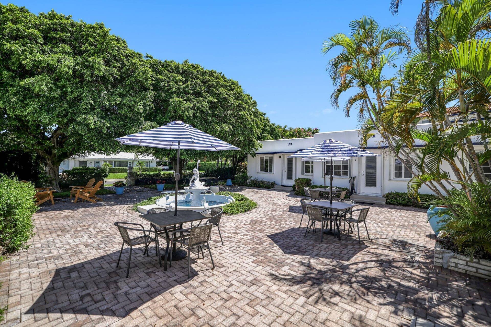 320 Inlet Way, #4, Palm Beach Shores, Palm Beach Shores, FL 33404 Expansive brick paver patio featuring a central fountain, mature trees, and lush landscaping