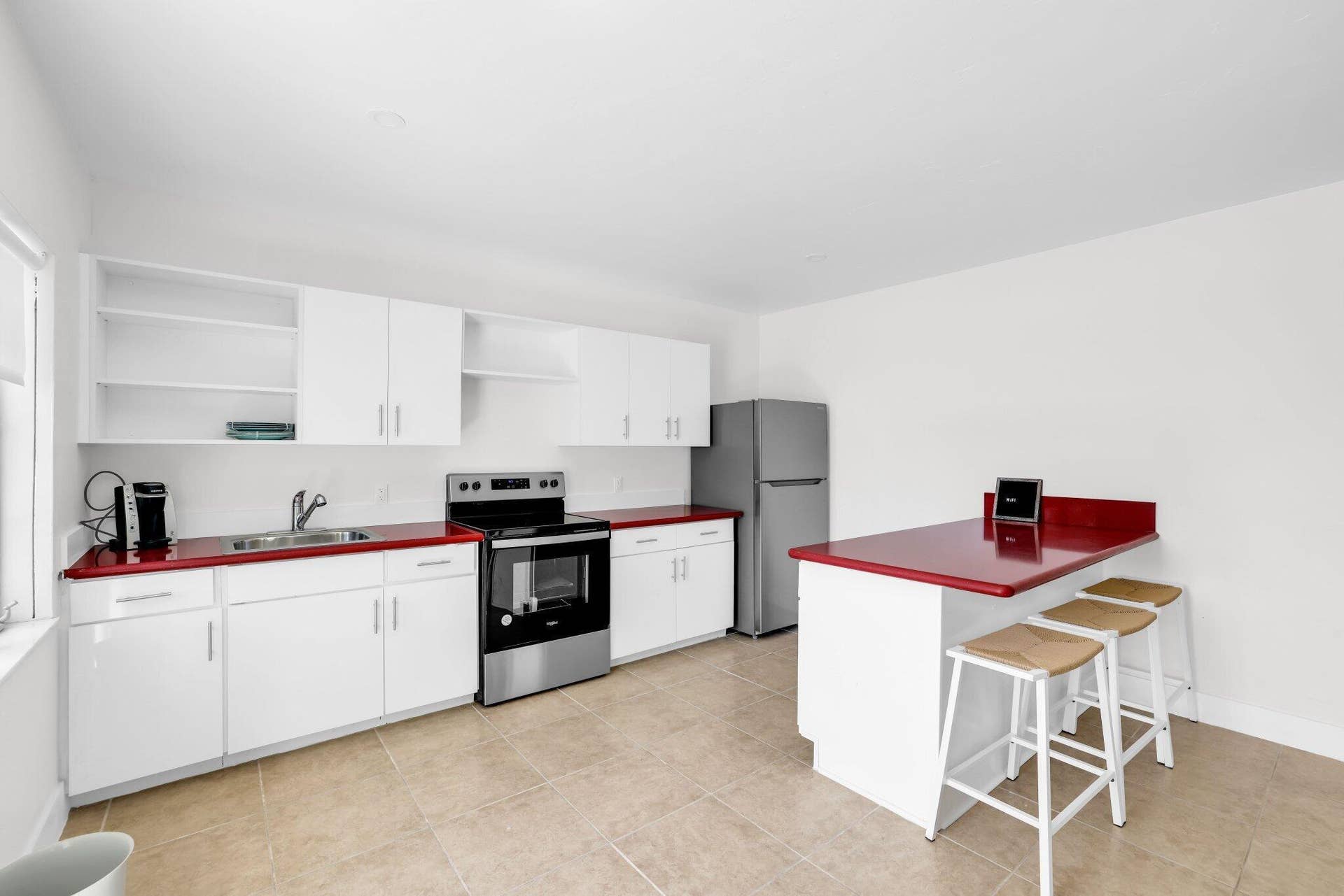 320 Inlet Way, #4, Palm Beach Shores, Palm Beach Shores, FL 33404 Contemporary kitchen featuring white cabinetry, red countertops, a stainless steel range, and an integrated breakfast bar