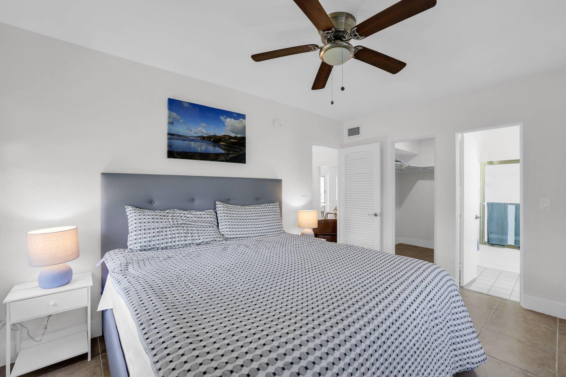 320 Inlet Way, #4, Palm Beach Shores, Palm Beach Shores, FL 33404 Bedroom featuring an upholstered headboard, ceiling fan with wood-finish blades, tile flooring, and white louvered closet doors