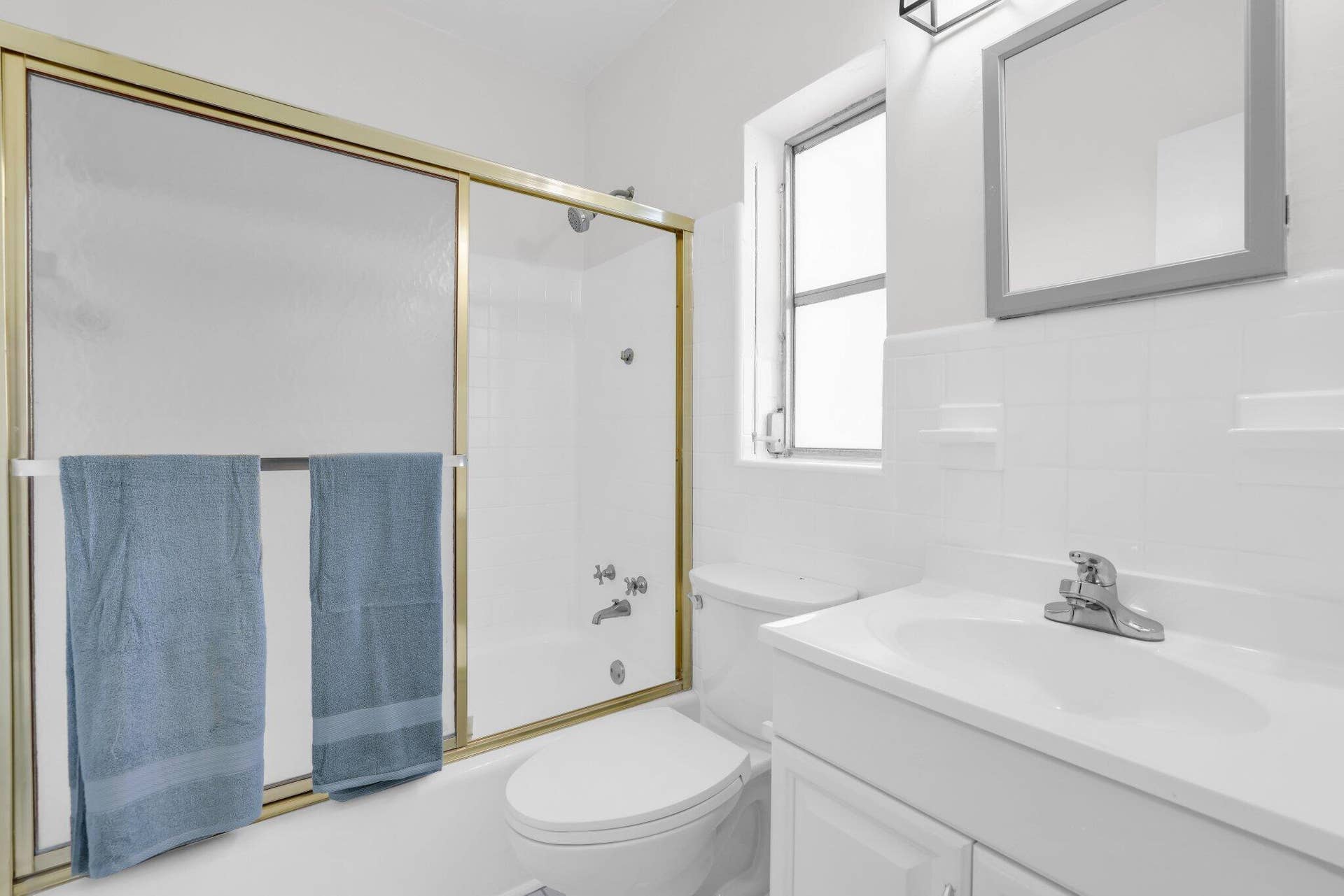 320 Inlet Way, #4, Palm Beach Shores, Palm Beach Shores, FL 33404 Bright bathroom with white ceramic tile walls, a white vanity with integrated sink, and a framed mirror