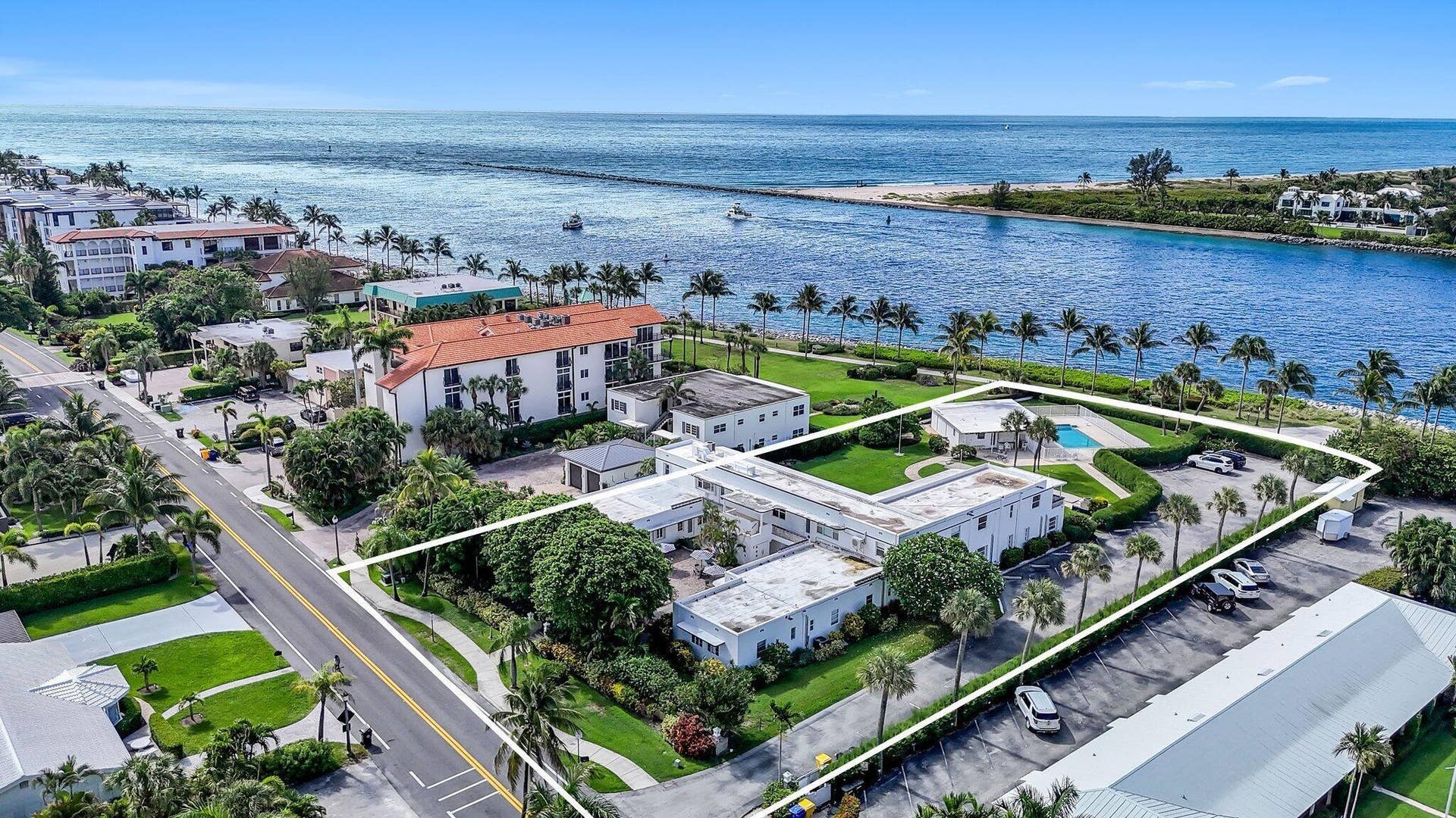 320 Inlet Way, #4, Palm Beach Shores, Palm Beach Shores, FL 33404 L-shaped residential building featuring a private swimming pool, mature palm trees, and direct access to a paved parking area