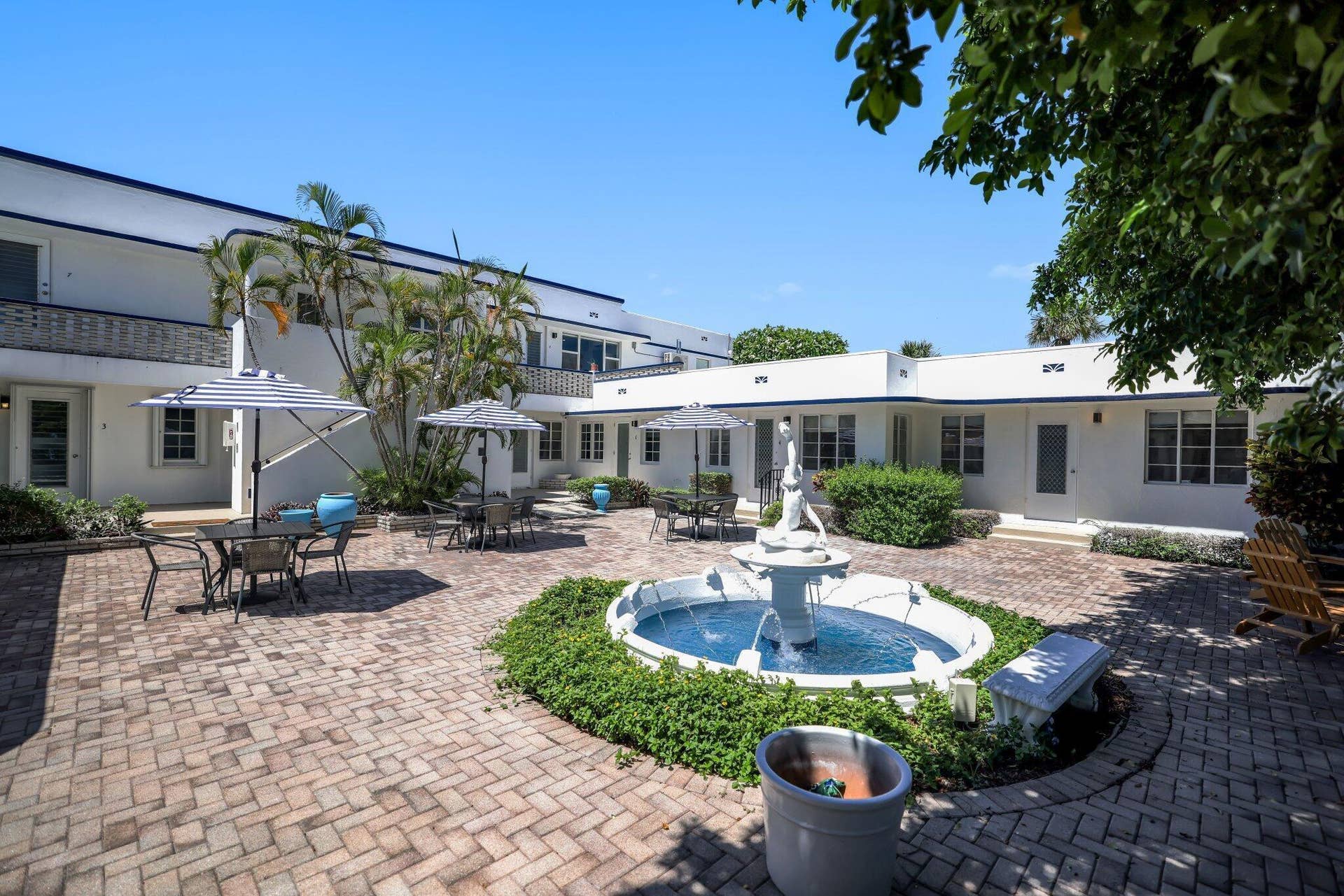 320 Inlet Way, #4, Palm Beach Shores, Palm Beach Shores, FL 33404 Central courtyard featuring a tiered fountain, brick paver flooring, and surrounding buildings with white facades