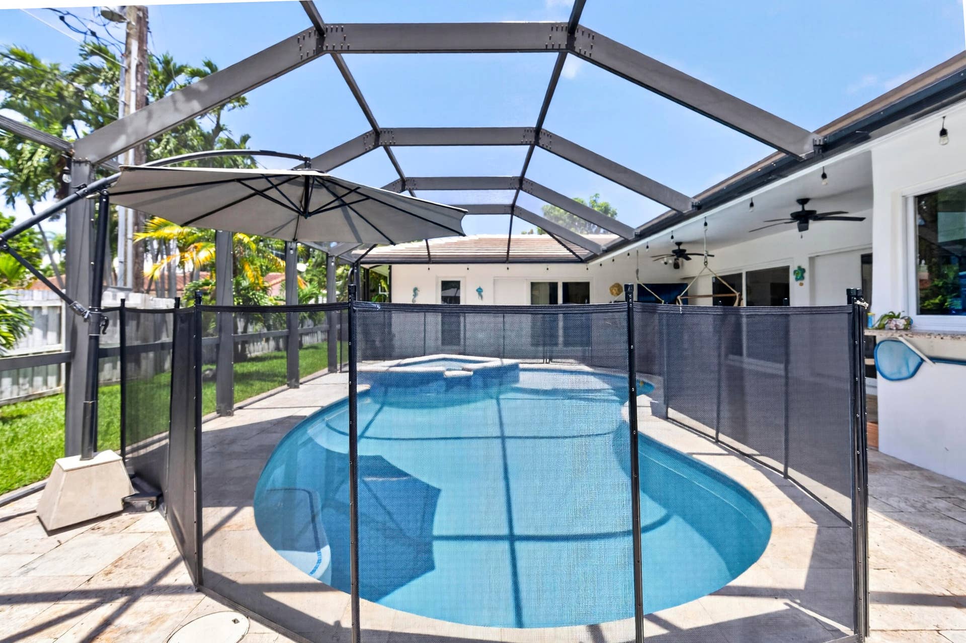 Screened-in outdoor pool enclosure featuring a pool safety fence