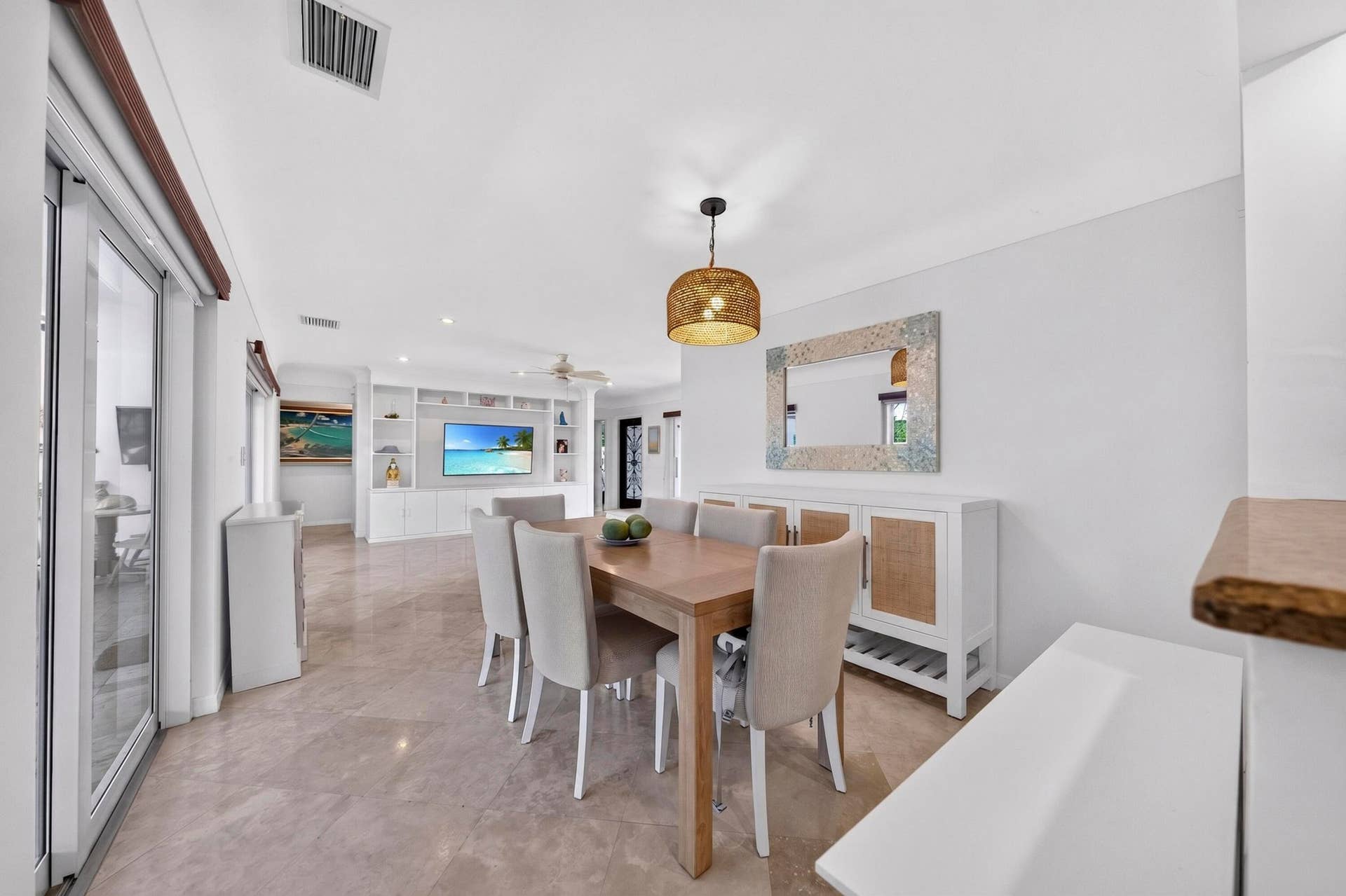 Open-concept living area featuring light-toned flooring, white walls, and a recessed ceiling with integrated lighting