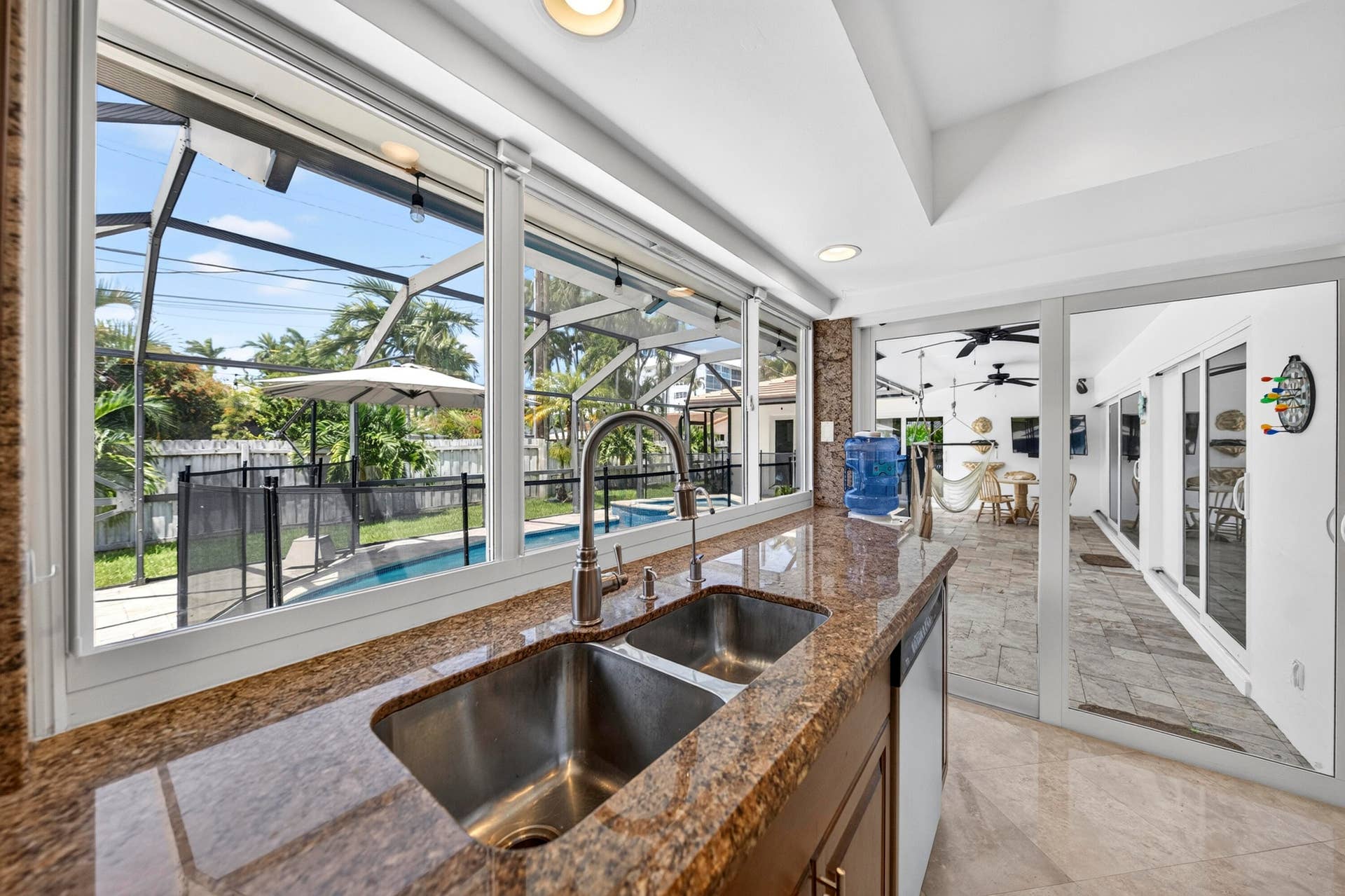 Kitchen featuring a double basin stainless steel sink, granite countertops, and wood cabinetry