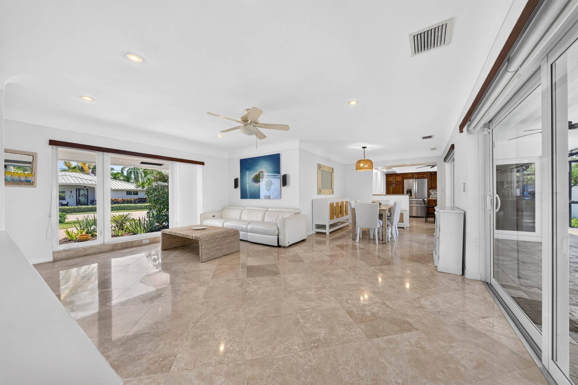 Spacious living area featuring large format tile flooring, recessed lighting, and a ceiling fan