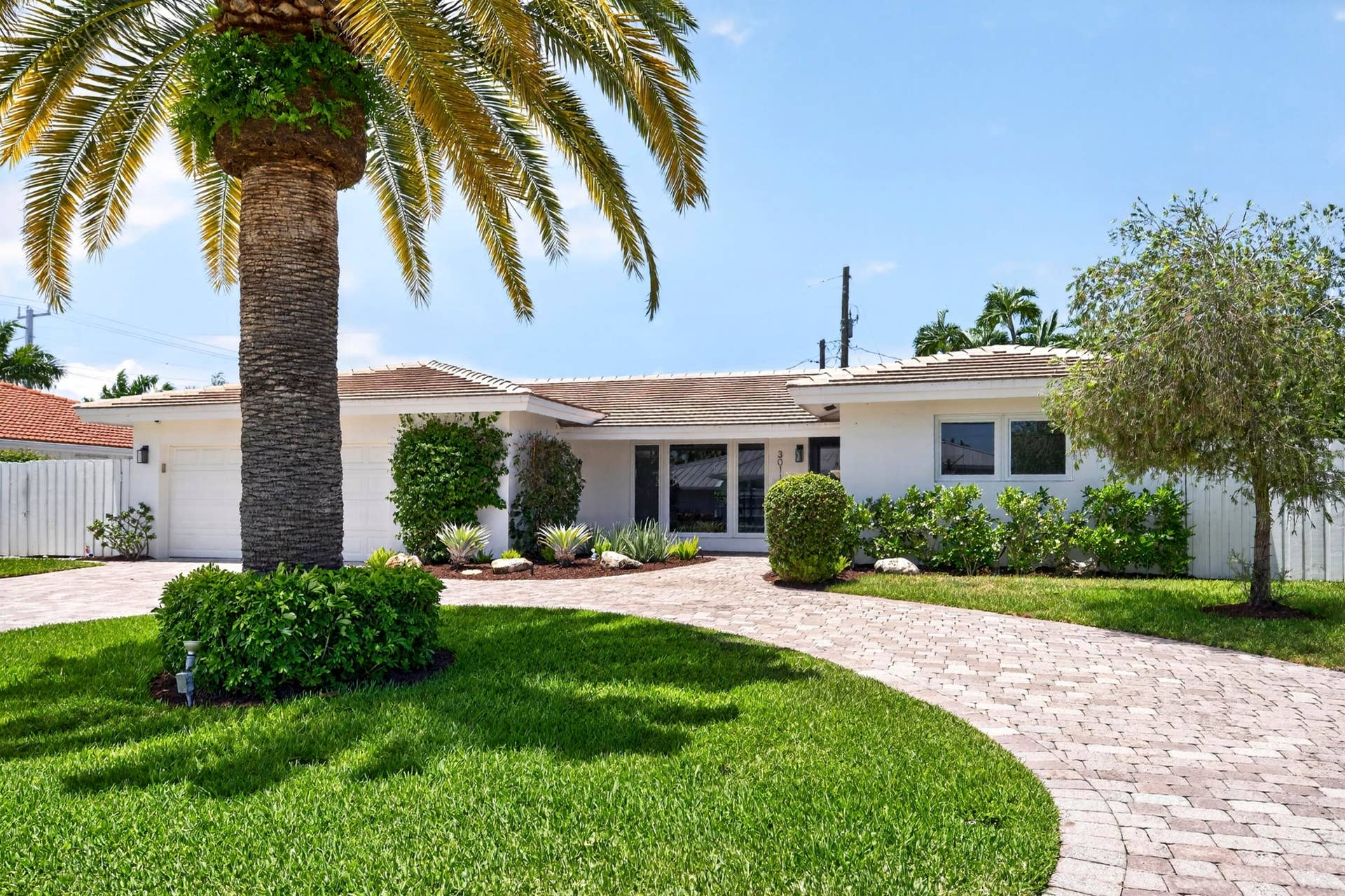 White exterior residence featuring a tiled roof and an attached garage with a white door