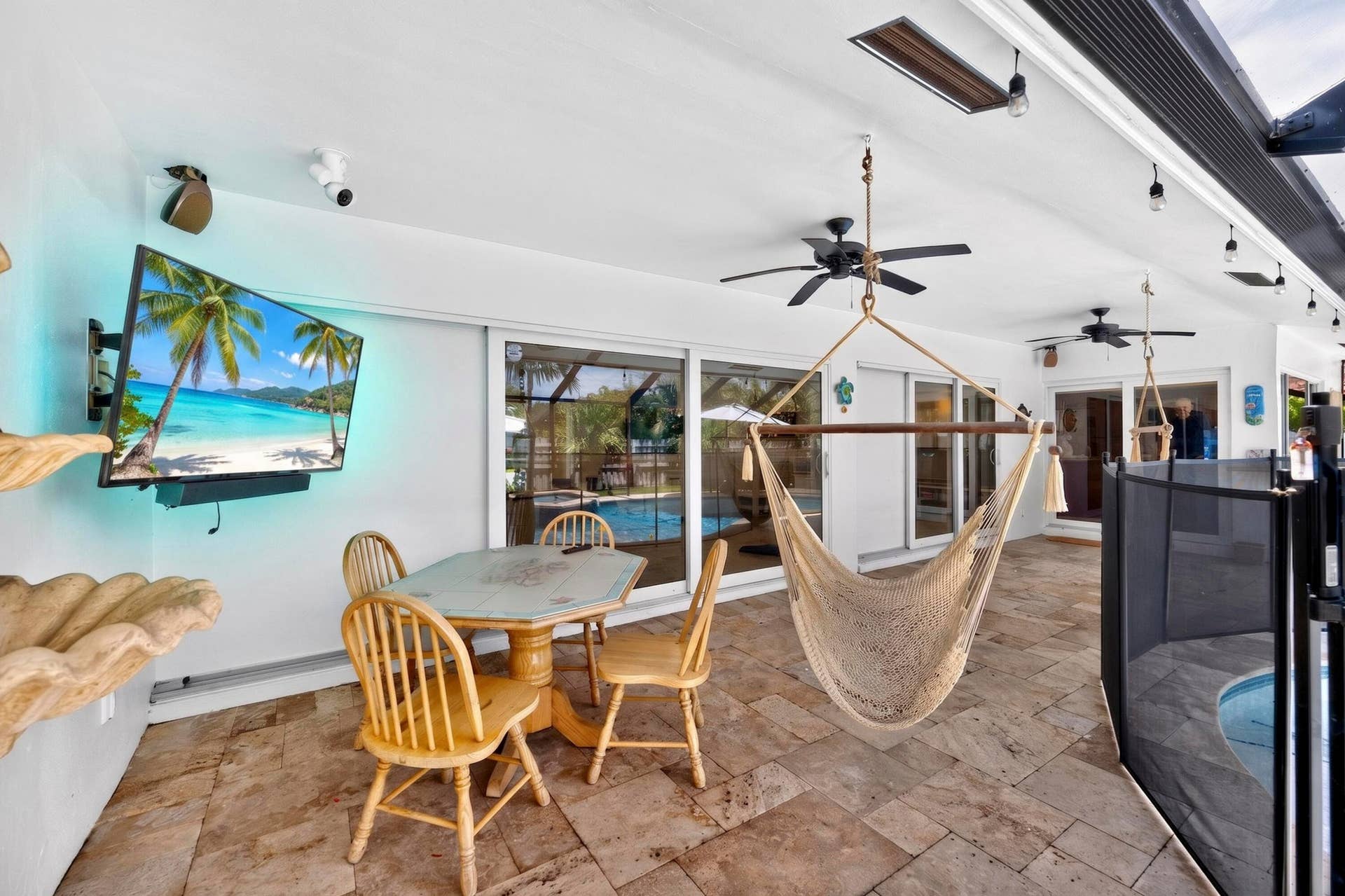 Covered patio featuring stone-finish flooring and multiple ceiling fans