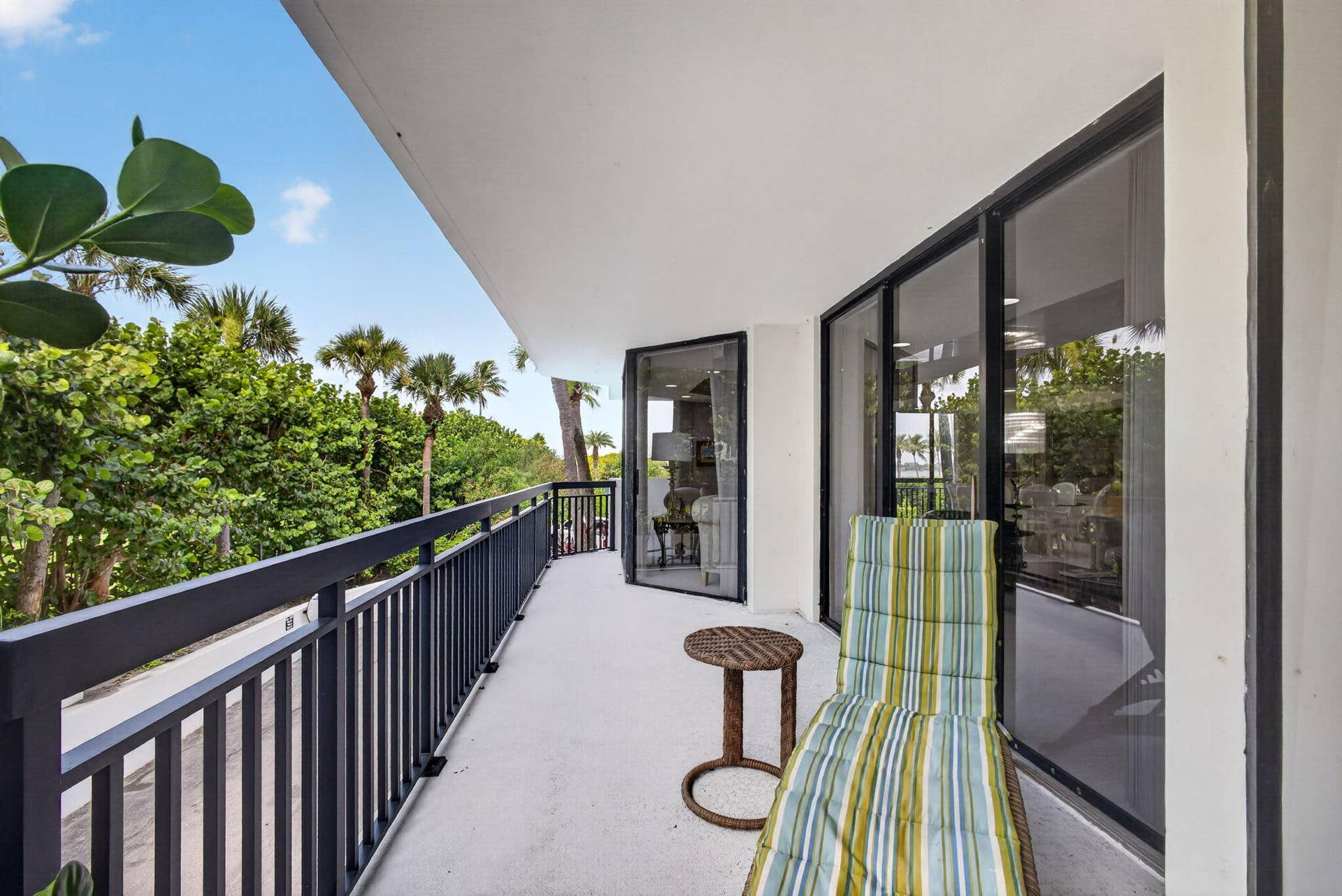 3140 S Ocean Boulevard, #101 S, Palm Beach, FL 33480 Spacious exterior balcony featuring a dark metal railing, concrete flooring, and sliding glass doors