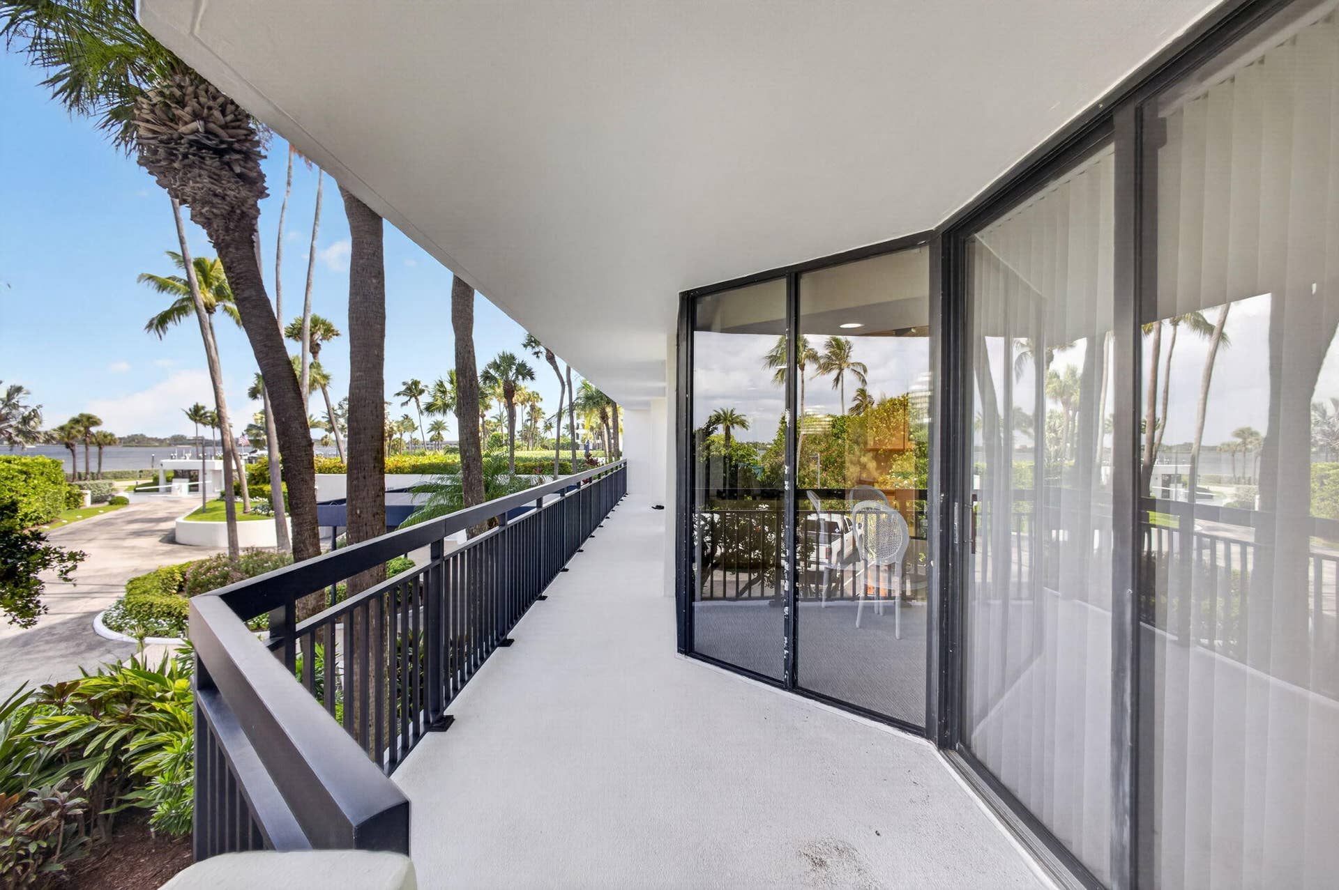3140 S Ocean Boulevard, #101 S, Palm Beach, FL 33480 Exterior balcony featuring a concrete floor, black metal railings, and floor-to-ceiling sliding glass doors