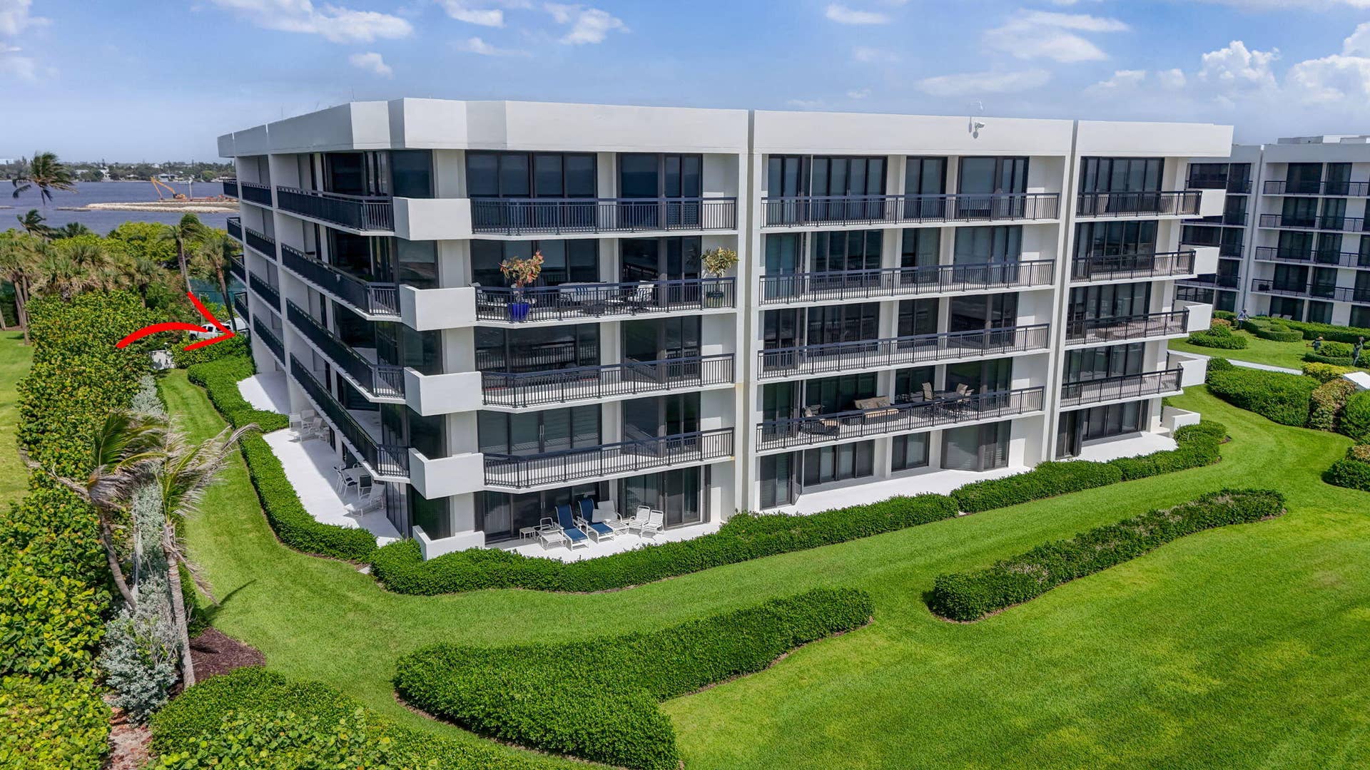 3140 S Ocean Boulevard, #101 S, Palm Beach, FL 33480 Contemporary multi-story building featuring expansive balconies, floor-to-ceiling glass doors, sleek black railings, and a white stucco exterior