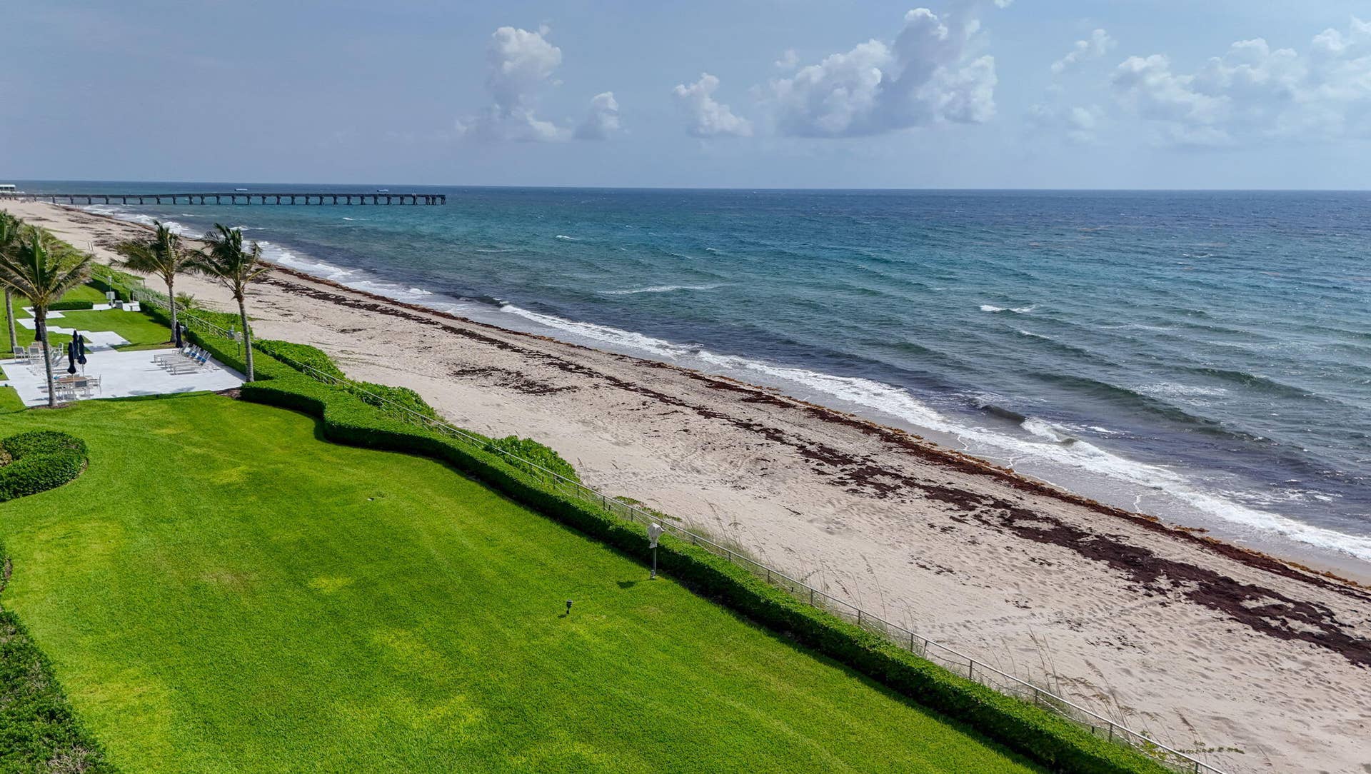 3140 S Ocean Boulevard, #101 S, Palm Beach, FL 33480 Manicured beachfront lawn with mature palm trees and paved patio areas