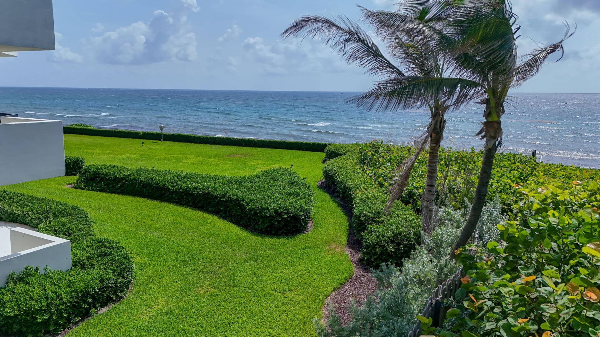 3140 S Ocean Boulevard, #101 S, Palm Beach, FL 33480 Expansive green lawn and manicured hedges bordering the ocean