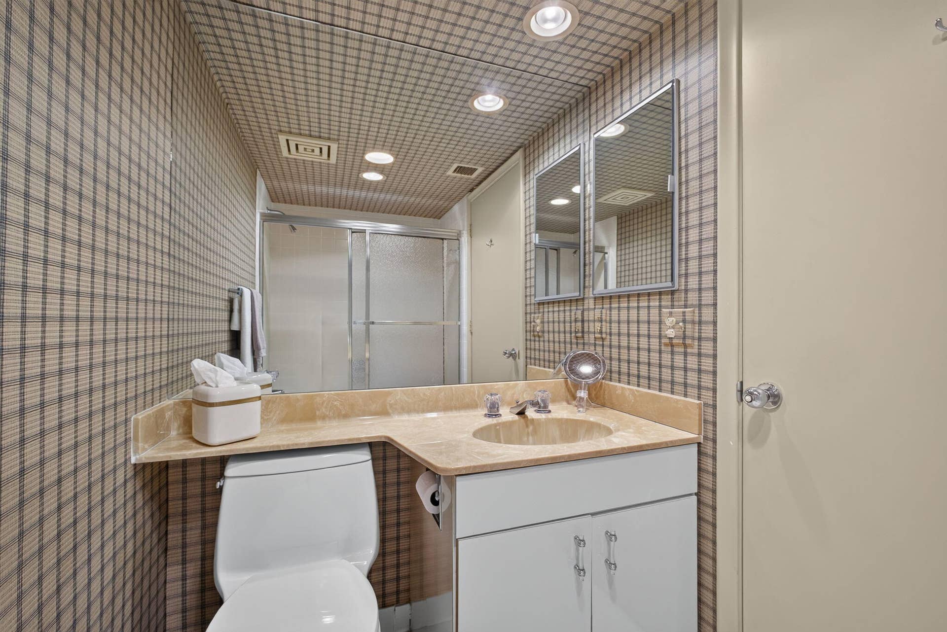 3140 S Ocean Boulevard, #101 S, Palm Beach, FL 33480 Bathroom featuring patterned wallpaper, a built-in vanity with an integrated sink and stone countertop, recessed lighting, and a shower with frosted glass enclosure