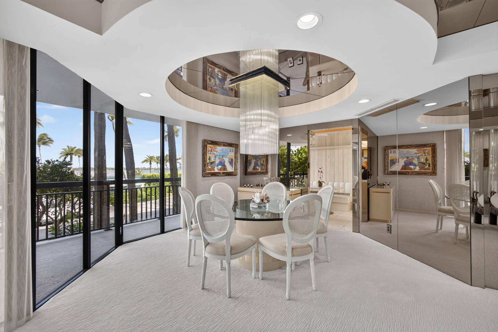 3140 S Ocean Boulevard, #101 S, Palm Beach, FL 33480 Dining area featuring floor-to-ceiling glass panel windows with outdoor access and a palm tree backdrop