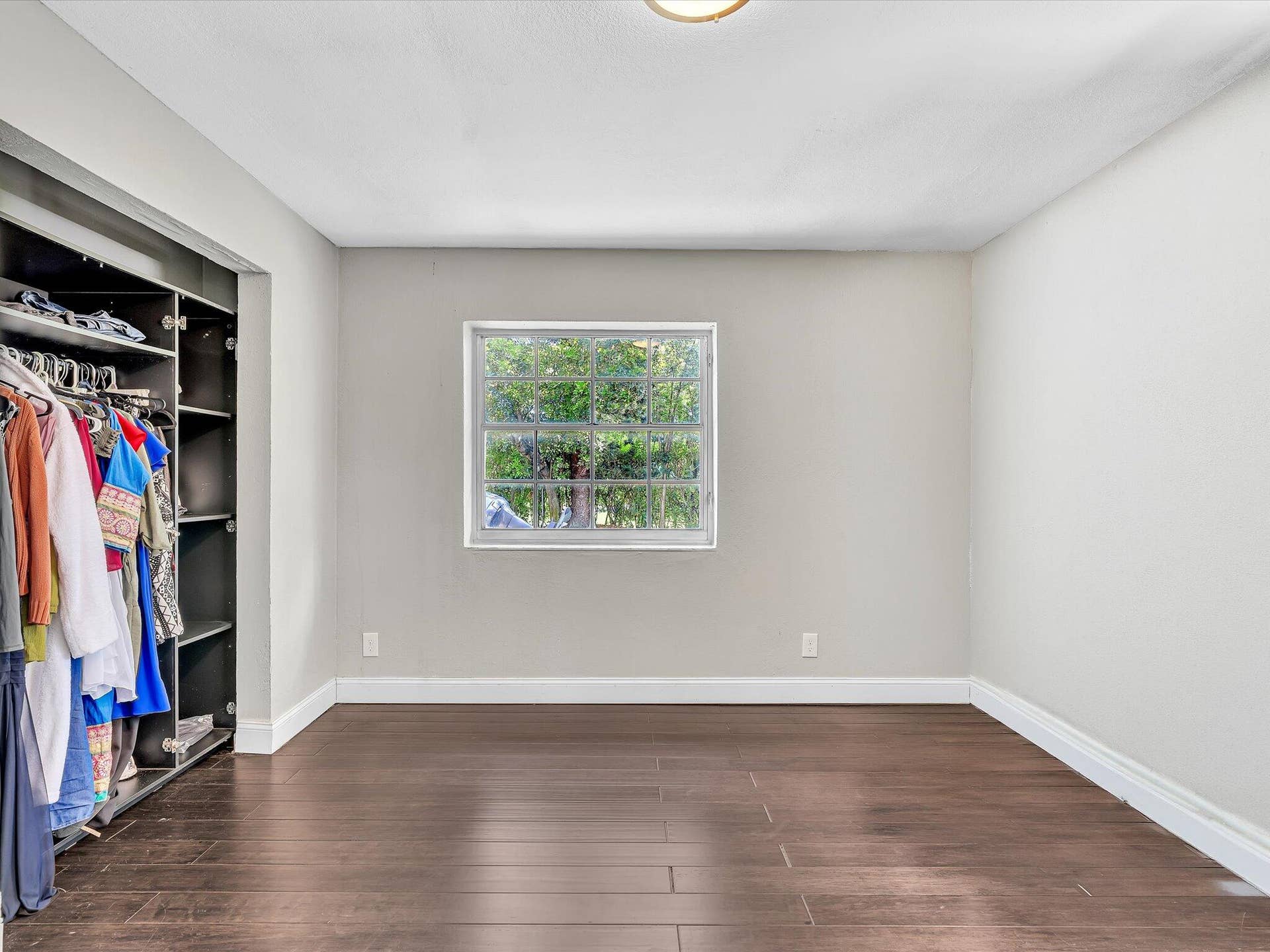 Recessed custom closet system, wood-finish flooring, and white baseboards