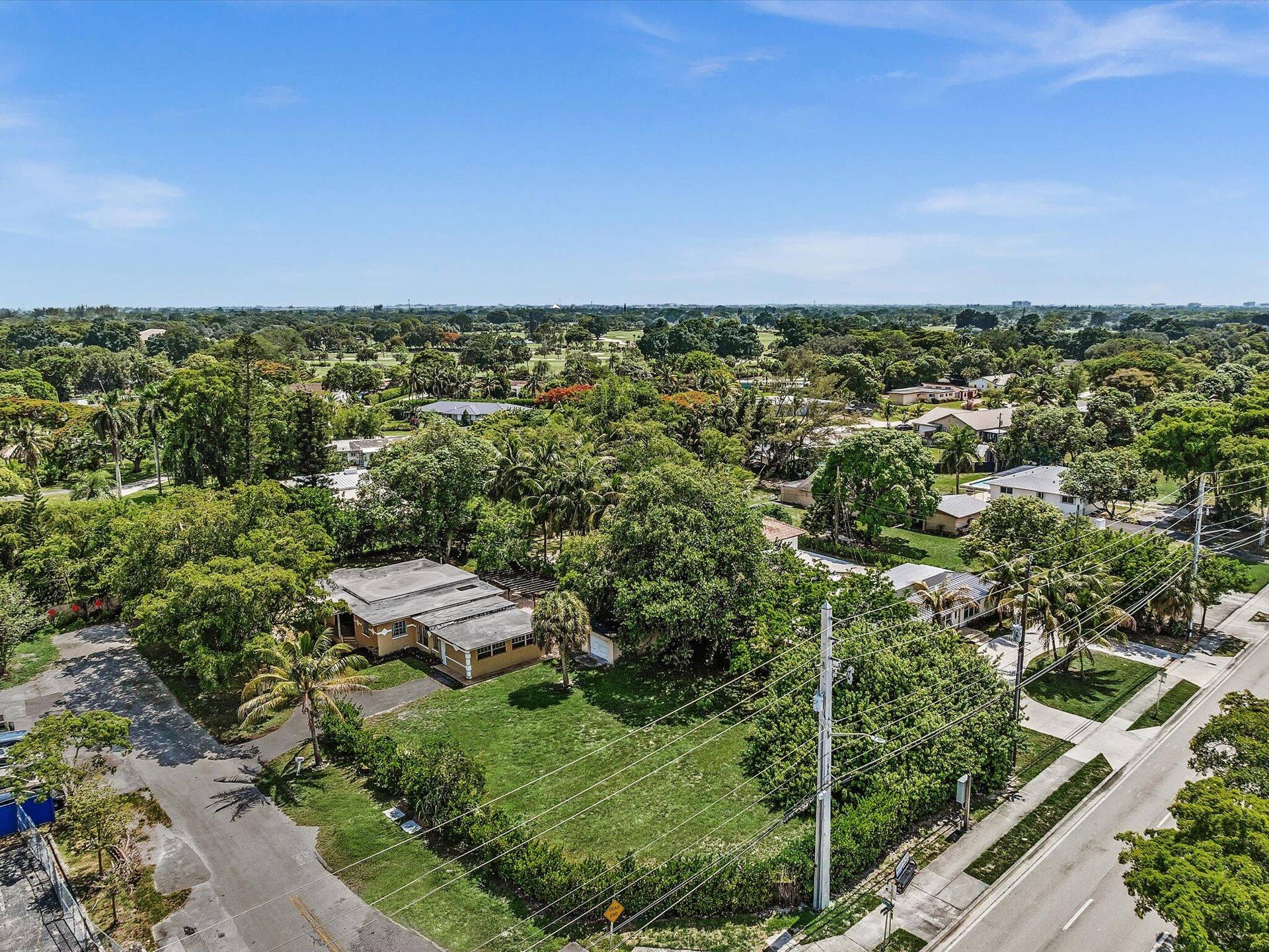 Expansive residential parcel featuring a single-story structure and verdant landscaping