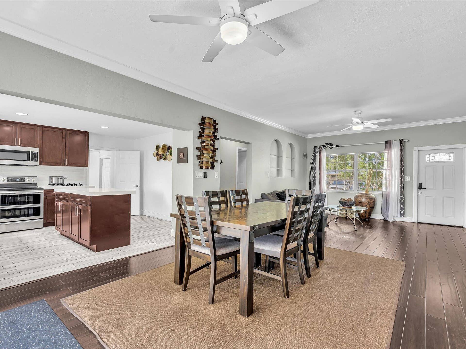 Open concept living space featuring rich wood-finish flooring and crown molding
