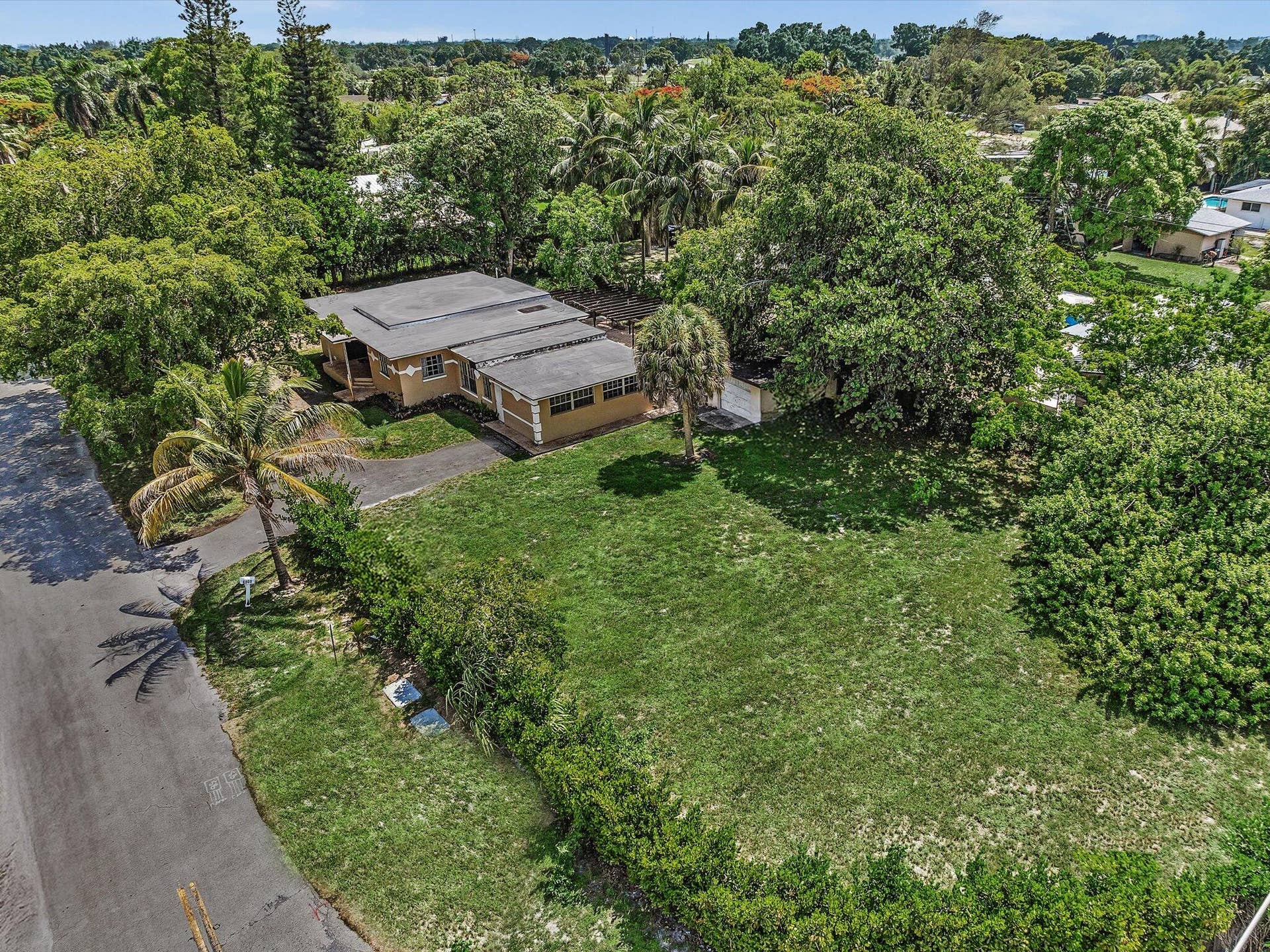 Expansive lot featuring a substantial grassy area, mature trees, and established perimeter landscaping