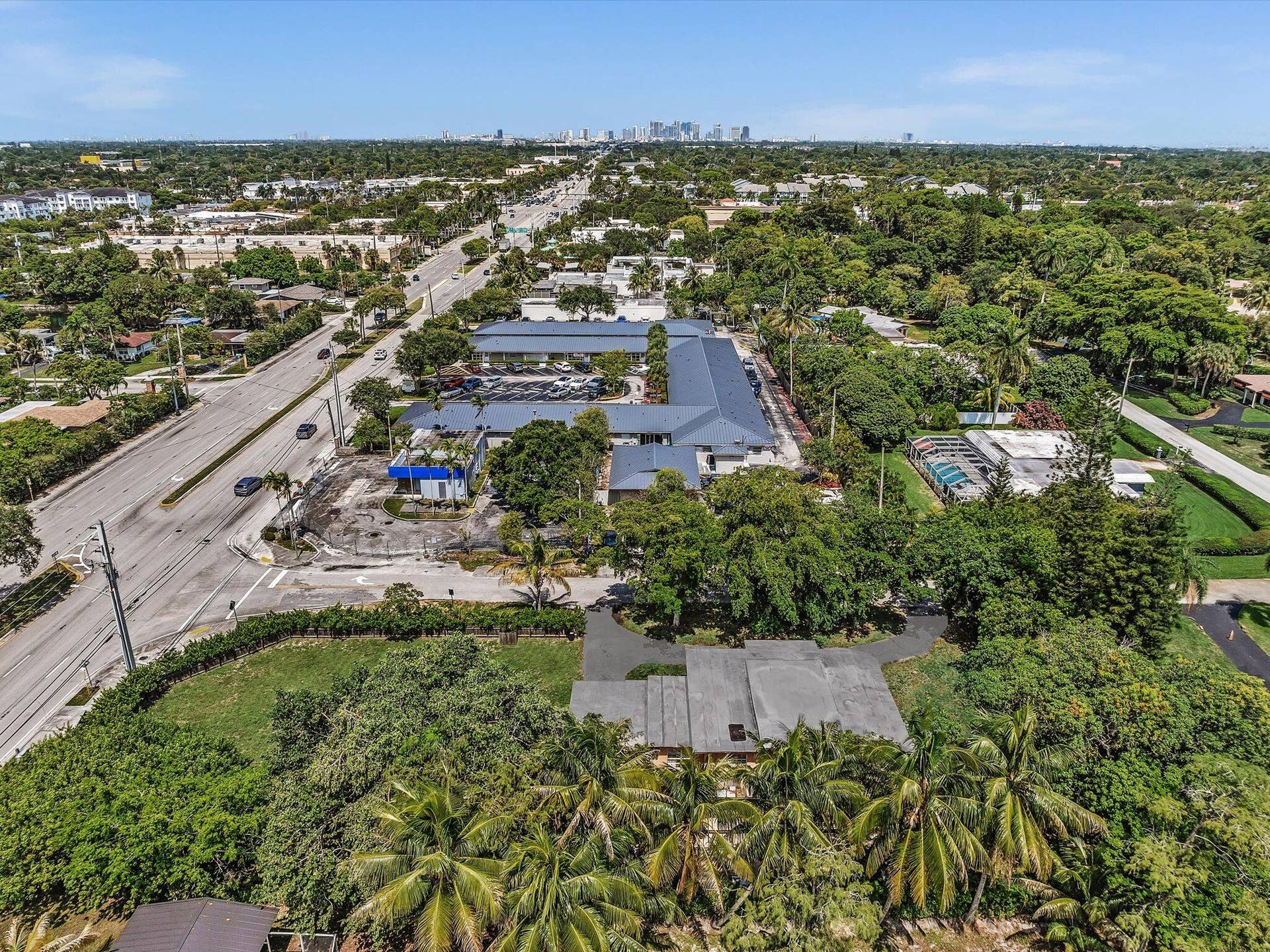 Aerial perspective showcasing a sprawling property with lush, mature landscaping and a generously sized paved driveway